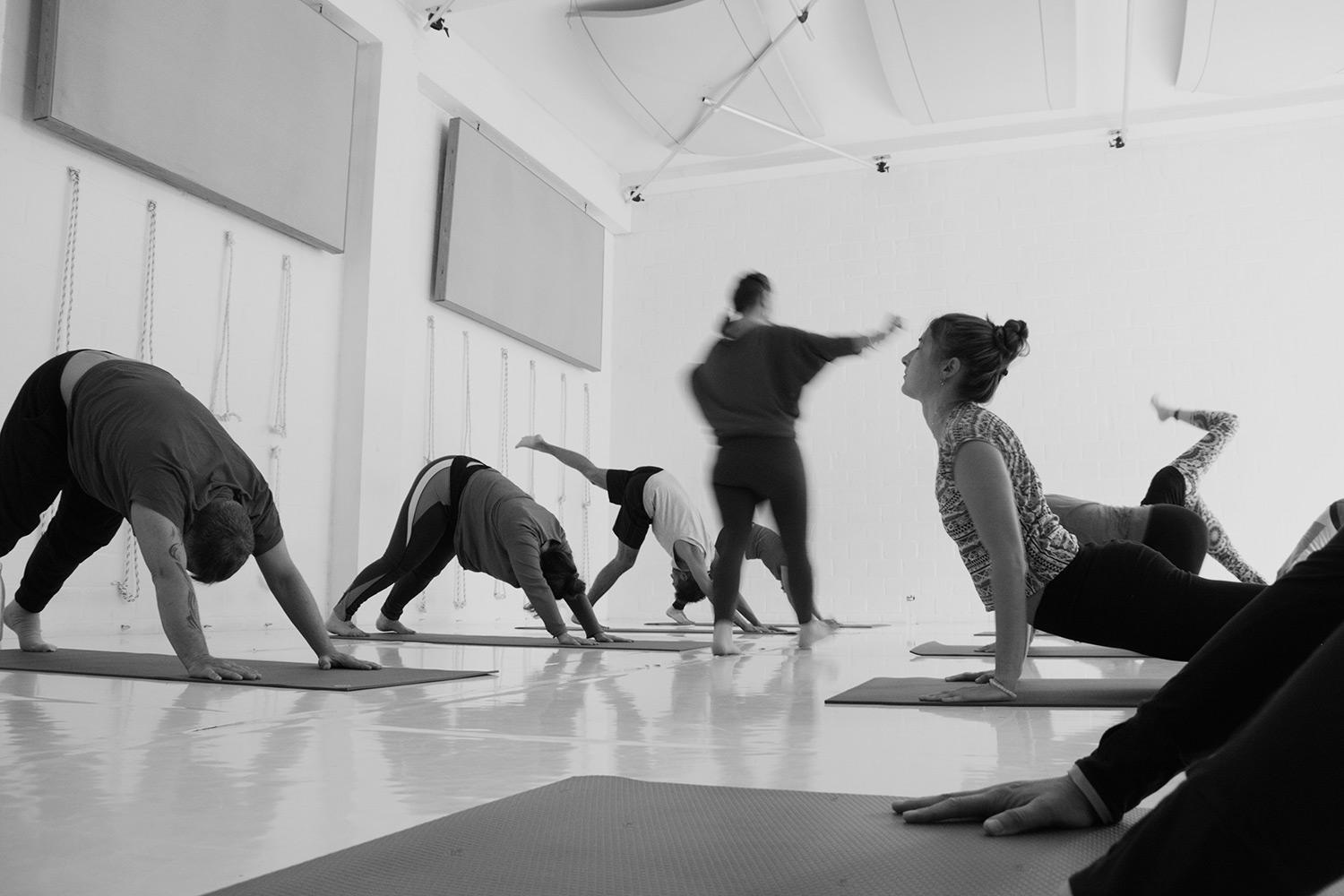 Varios estudiantes realizan yoga en un audiotorio