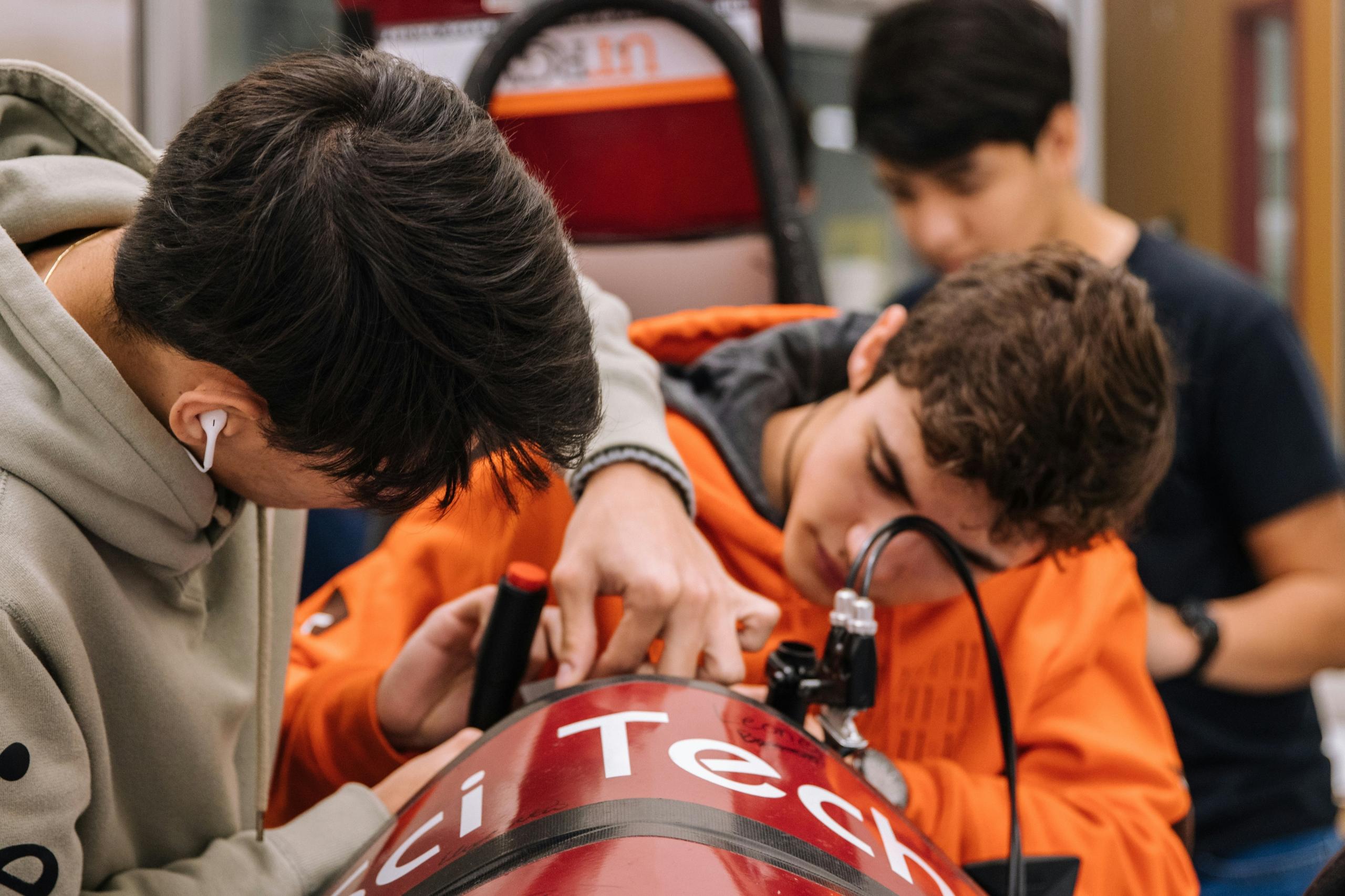 Imagen de estudiantes trabajando en equipo en un proyecto donde están experimentando con máquinas.