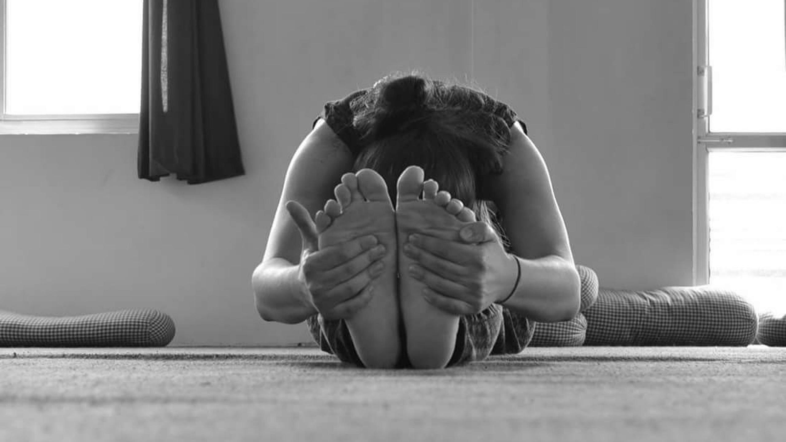Una postura de yoga que consiste en llevar el cuerpo hacia adelante y agarrase la planta de los pies con las manos