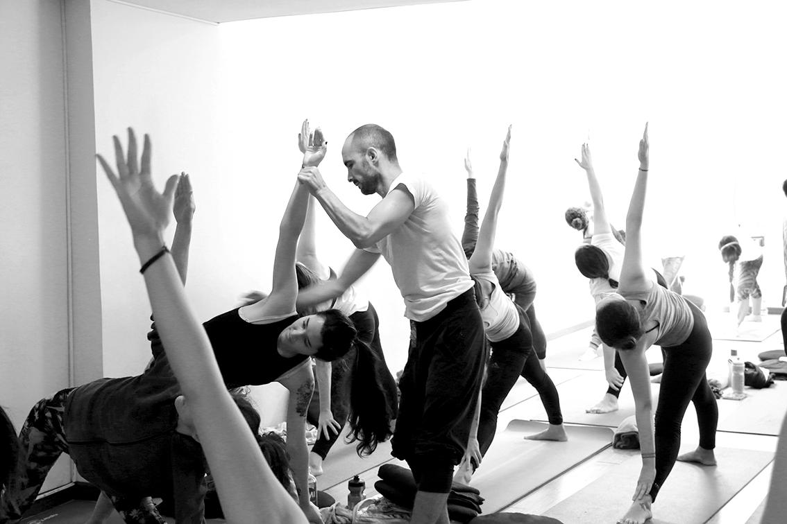 Clase de yoga en la que aparece un profesor con sus estudiante