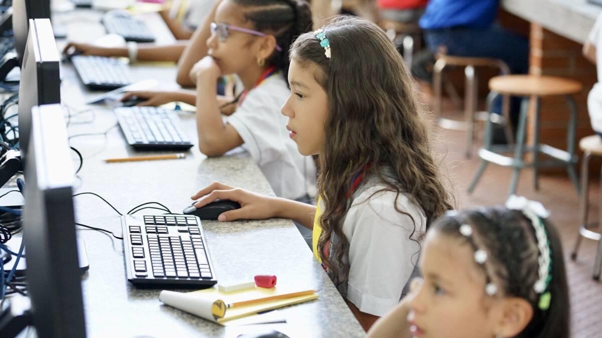 Varios estudiantes de primera estudiando frente a la computadora