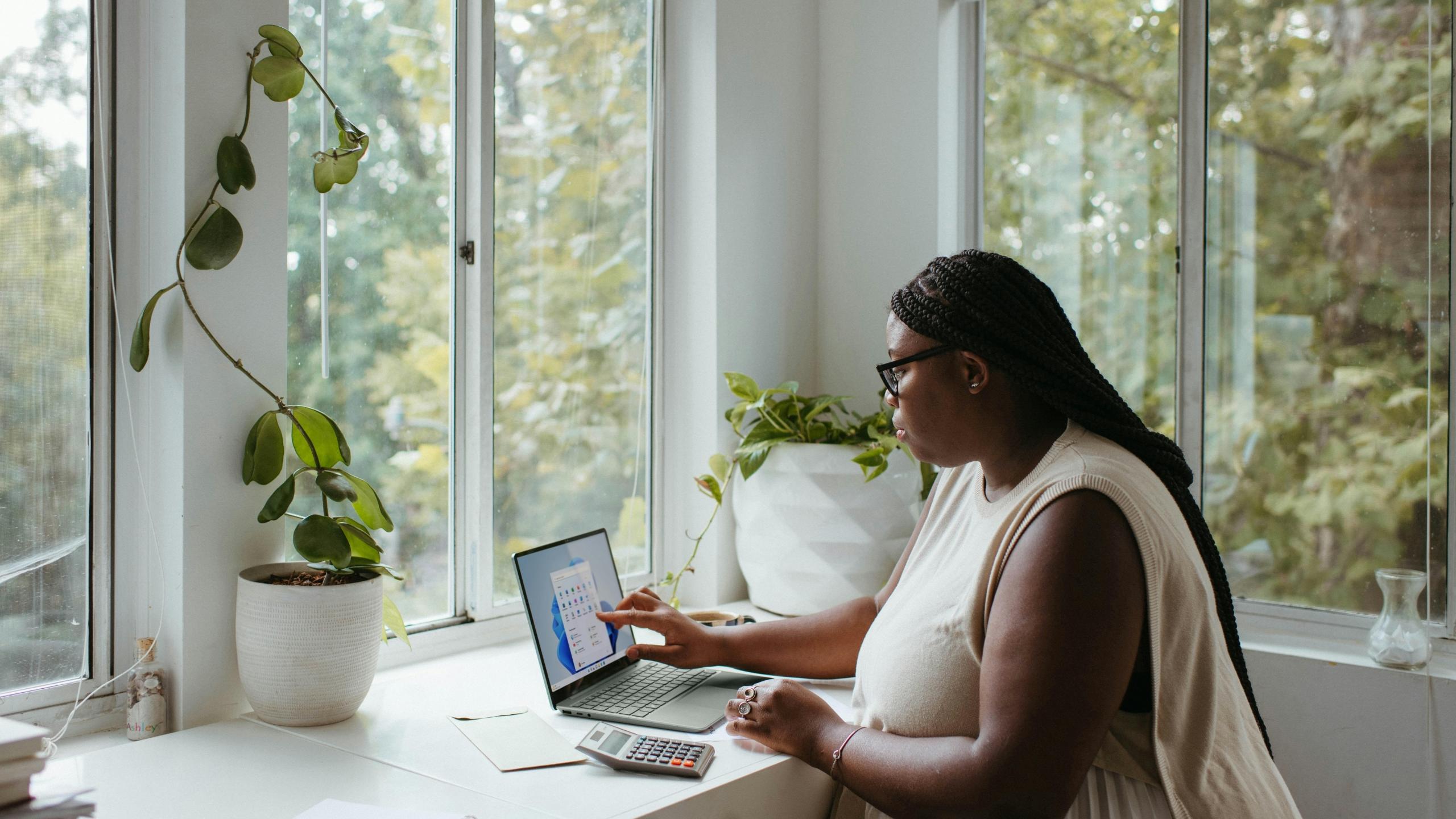 Imagen de una mujer en su escritorio realizando la gestión de sus finanzas en excel.
