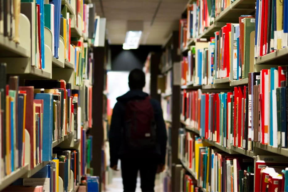 Pasillo de una biblioteca y un estudiante