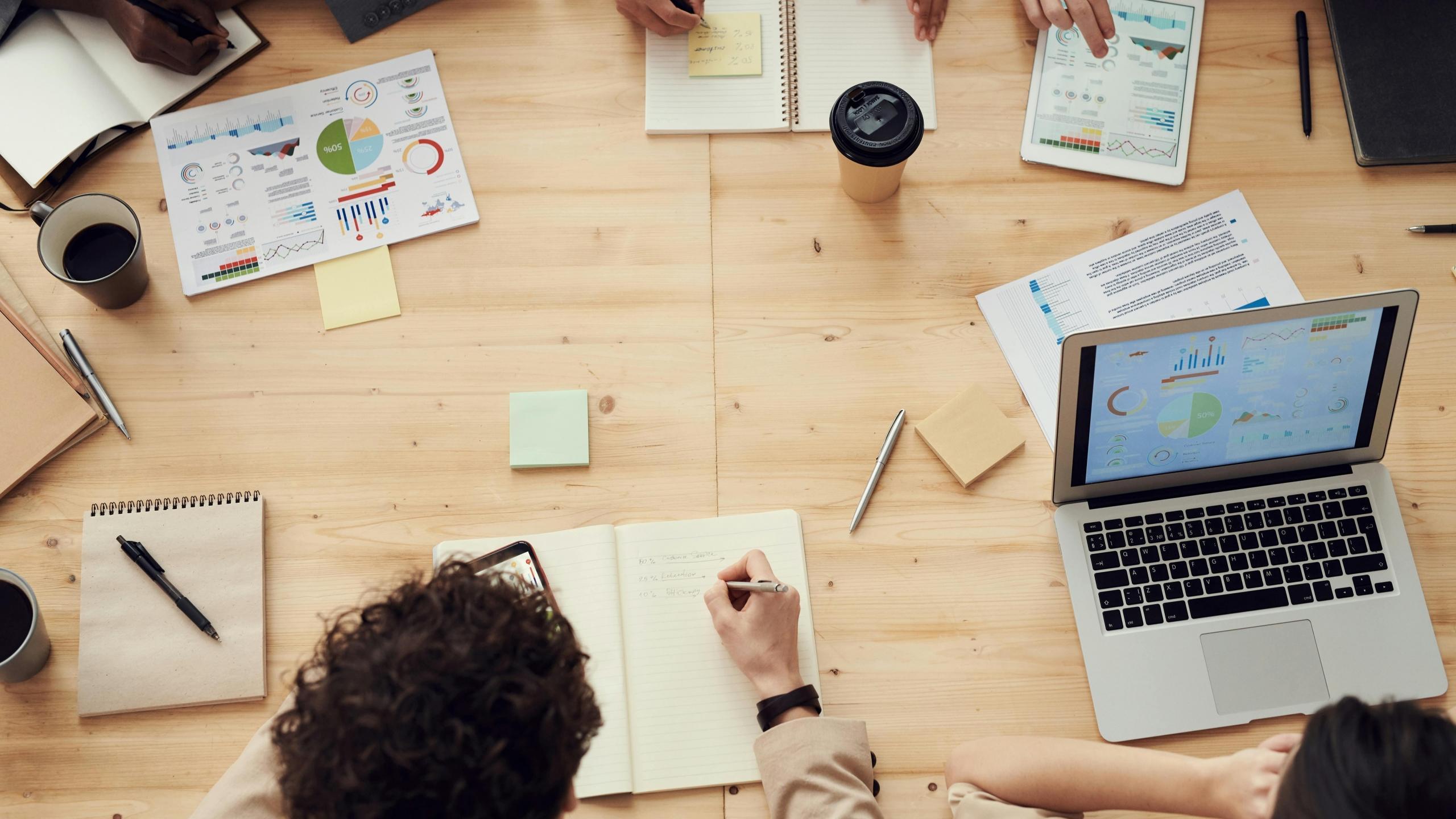 Mesa de trabajo en donde se observan varias horas con gráficos estadisticos y analisis de datos.