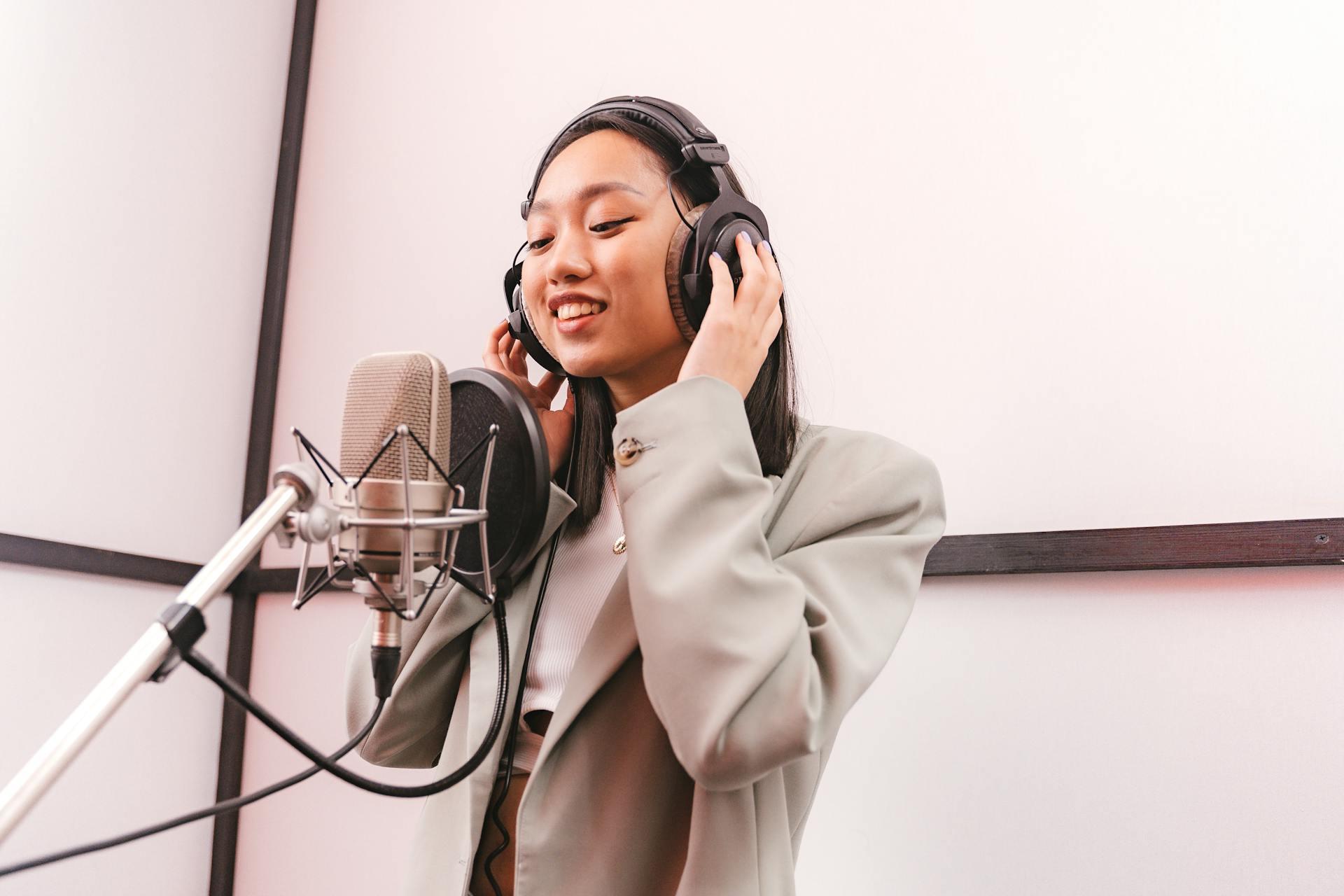 Imagen de una mujer cantando en un estudio de música con micrófono