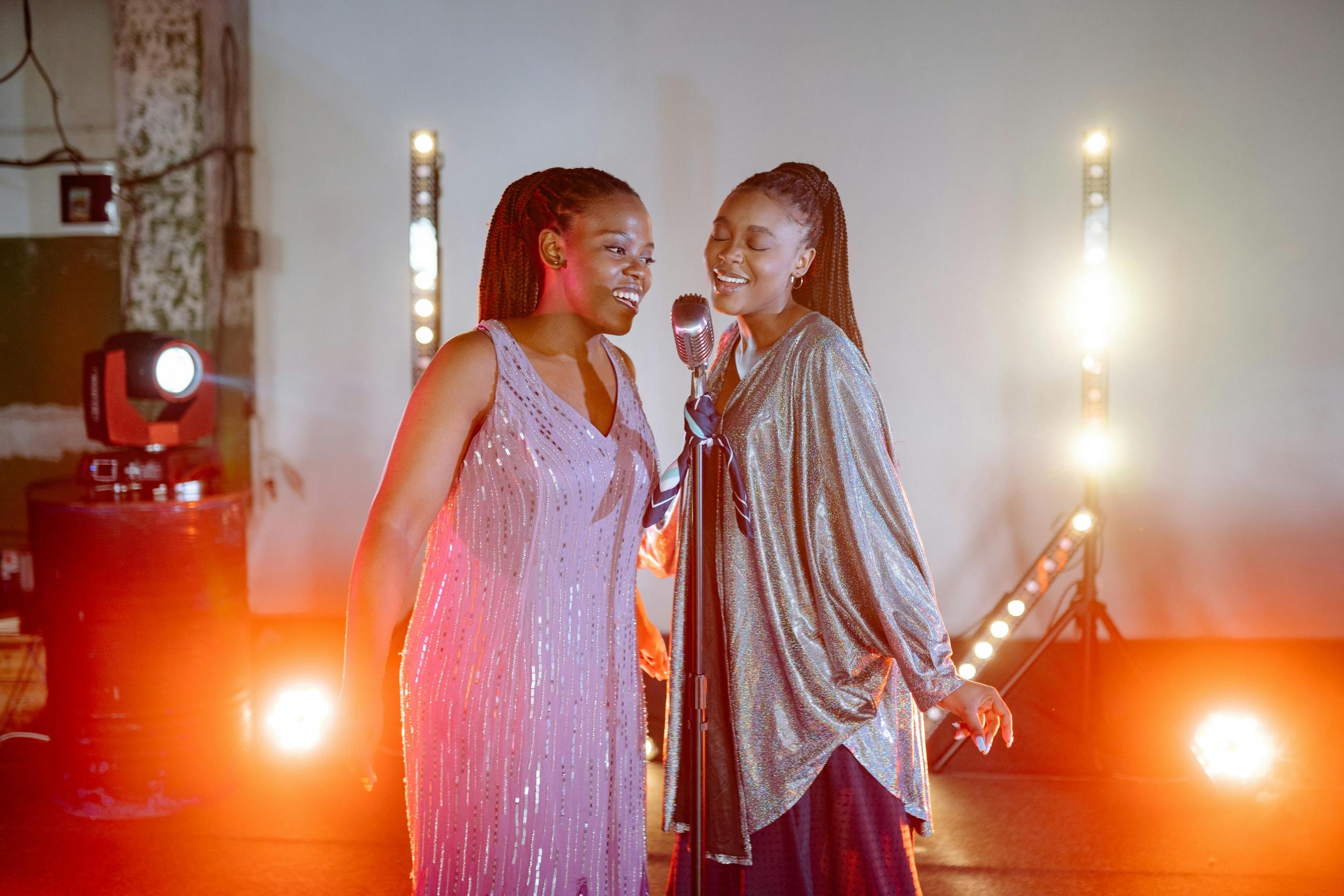 Dos cantantes mujeres en un Jam session con luces de fondo