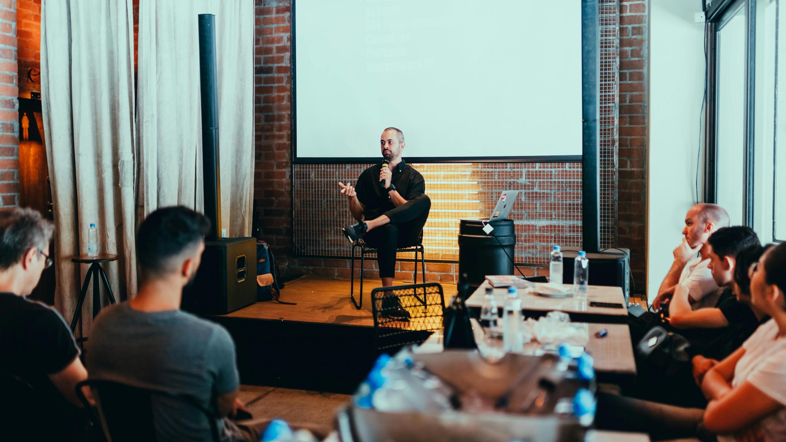 Imagen de un hombre dando una conferencia a su equipo de trabajo en ingles