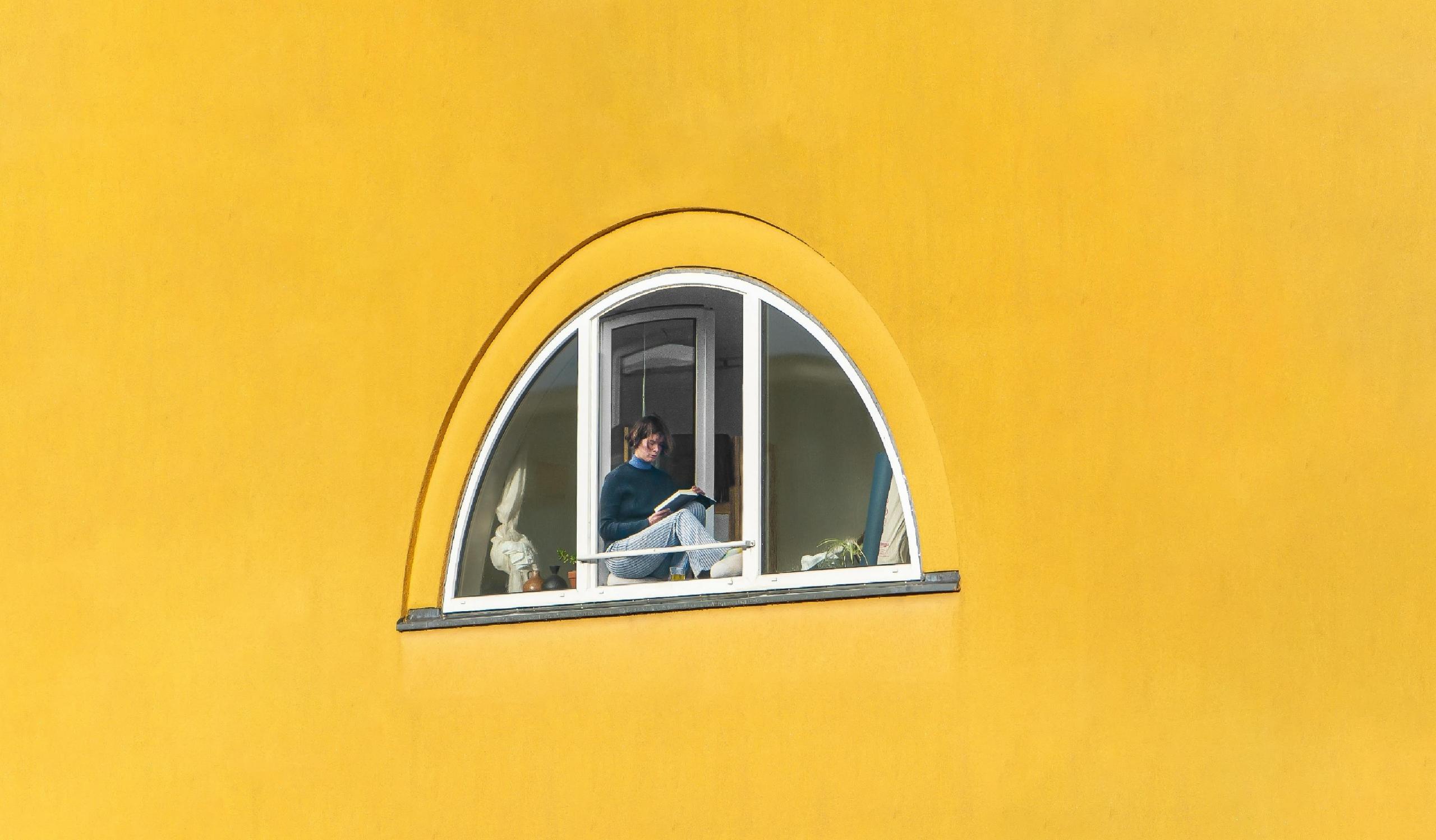 Mujer en una Ventana De Vidrio Con Marco Blanco En forma de semicirculo