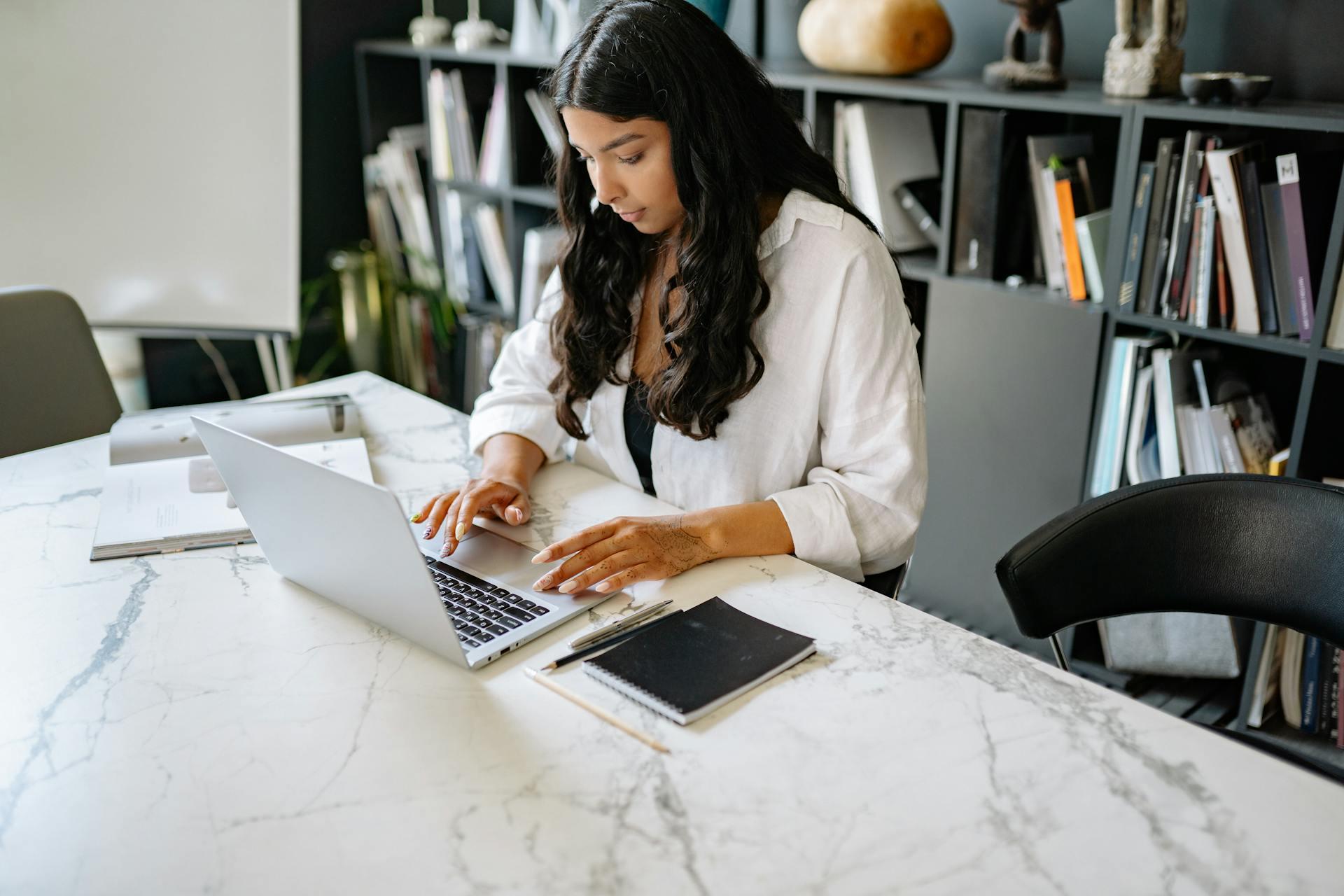 Mujer sentada en el sofá usando una Mackbook