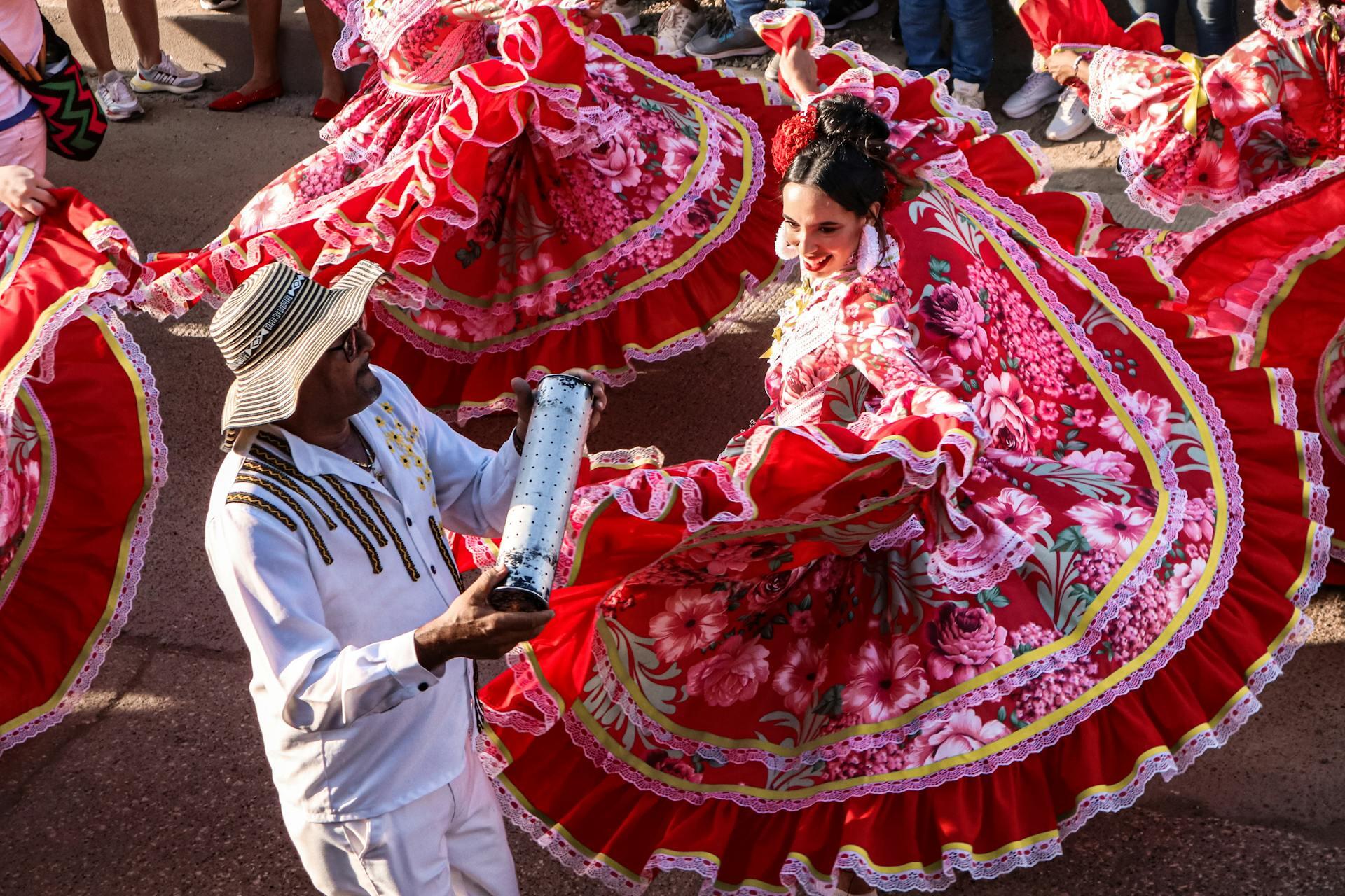 Pareja de colombianos bailando con trajes e instrumentos regionales