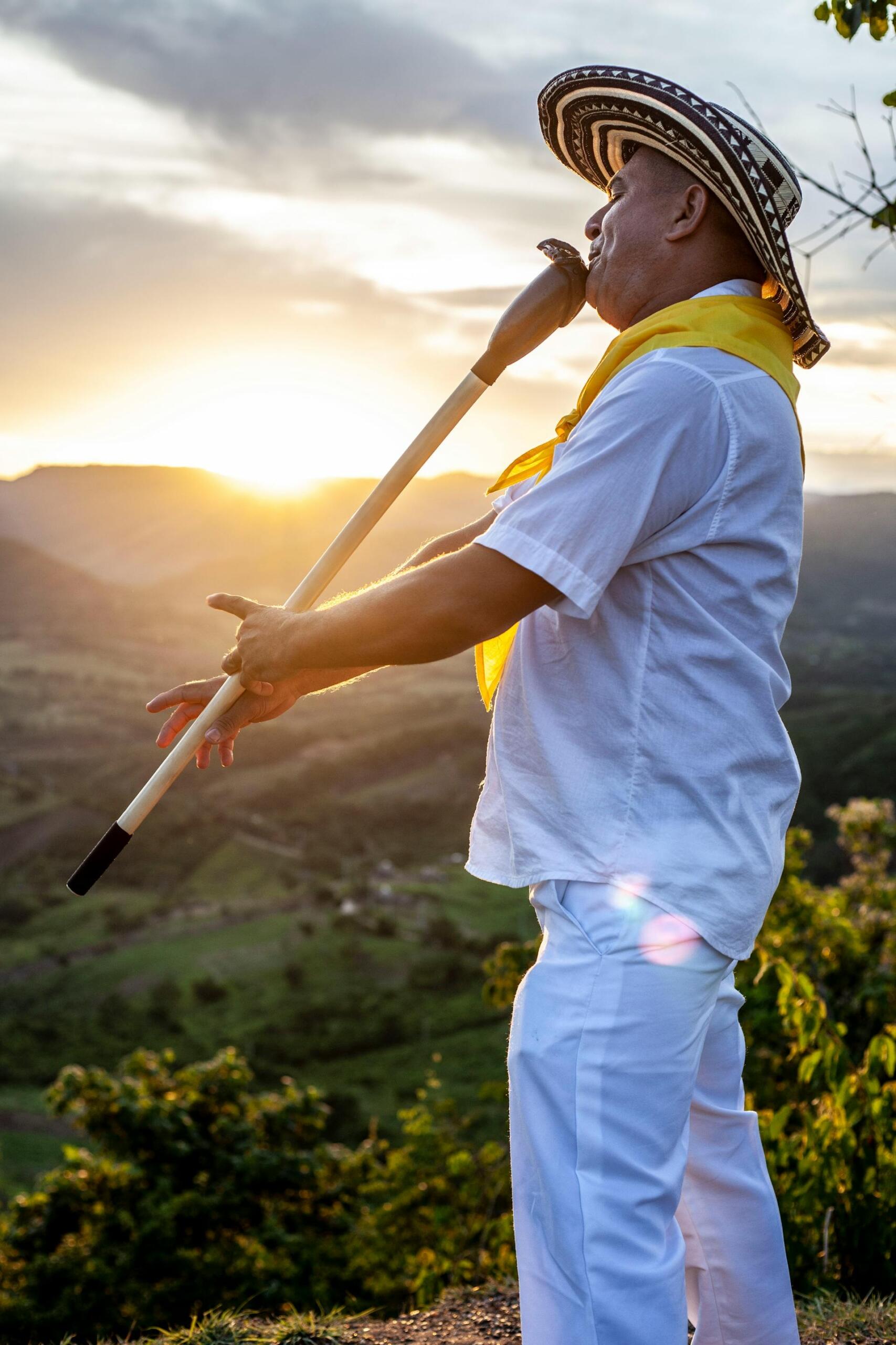Hombre tocando una flauta tradicional colombiana en las montañas