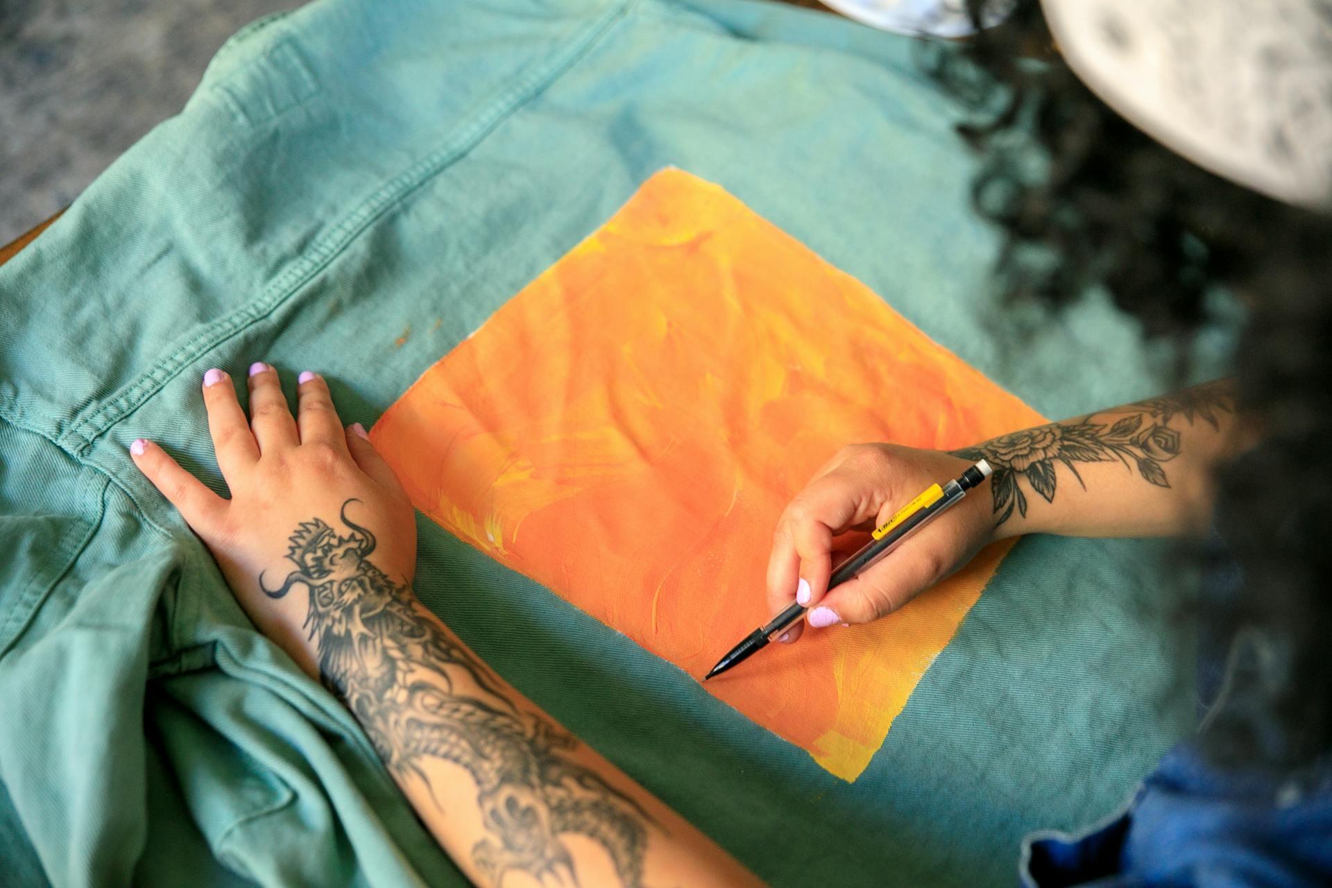 Mujer pintando a mano una chaqueta de jean
