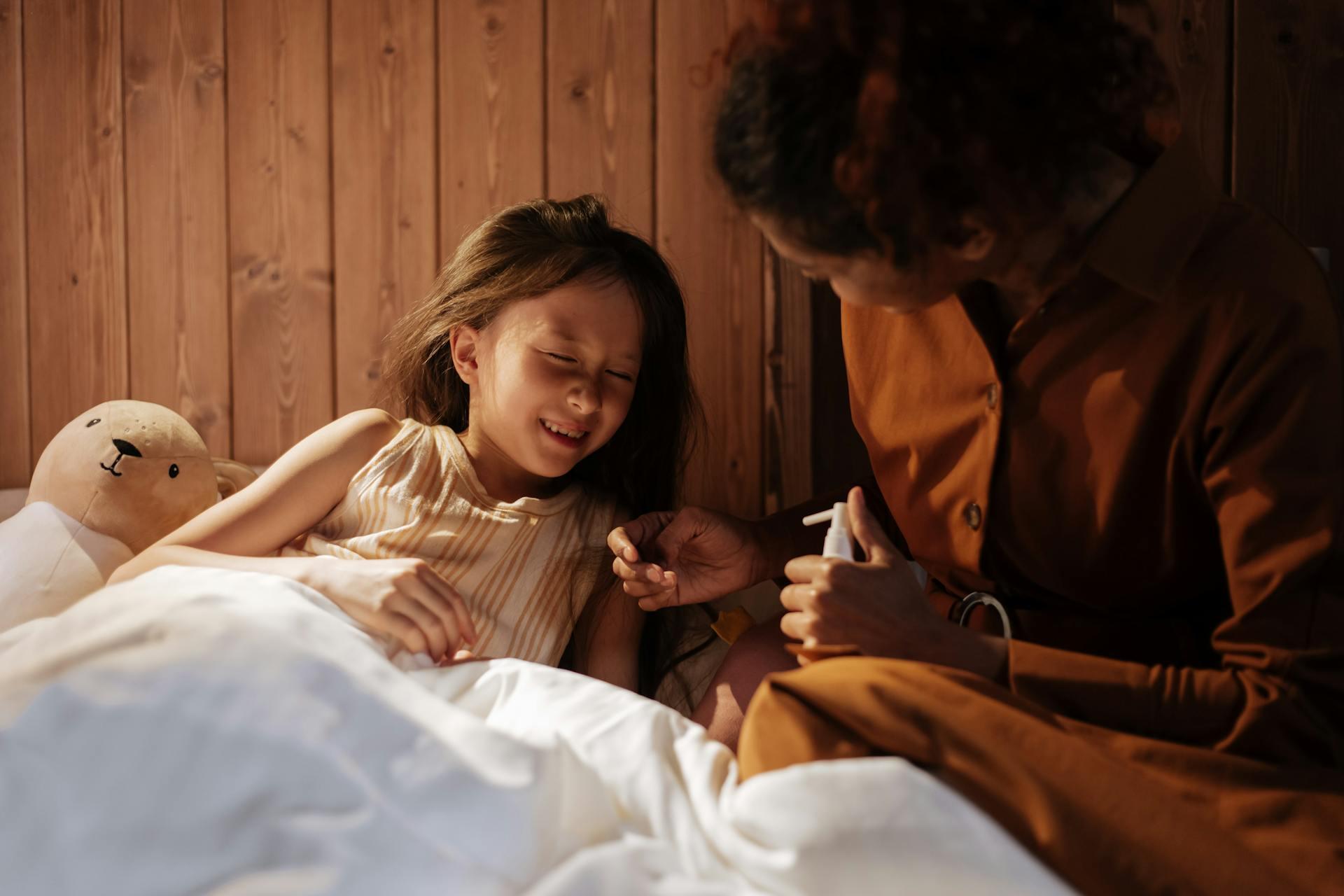 Madre curando el dolor de cabeza de su hija