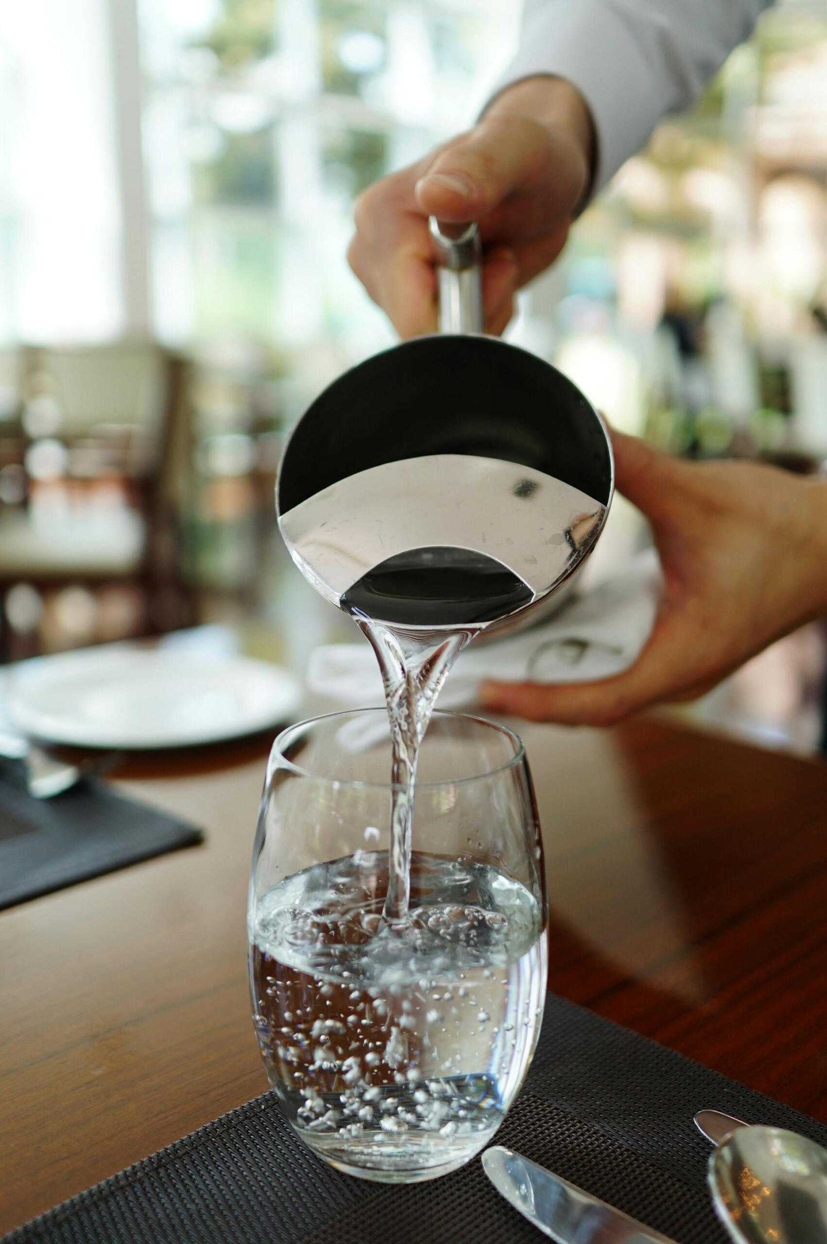 Persona sirviendo un vaso de agua