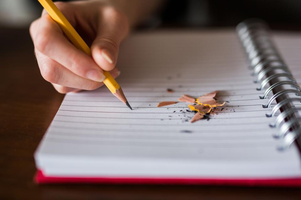 Tomando notas en libreta con un lápiz de buena punta