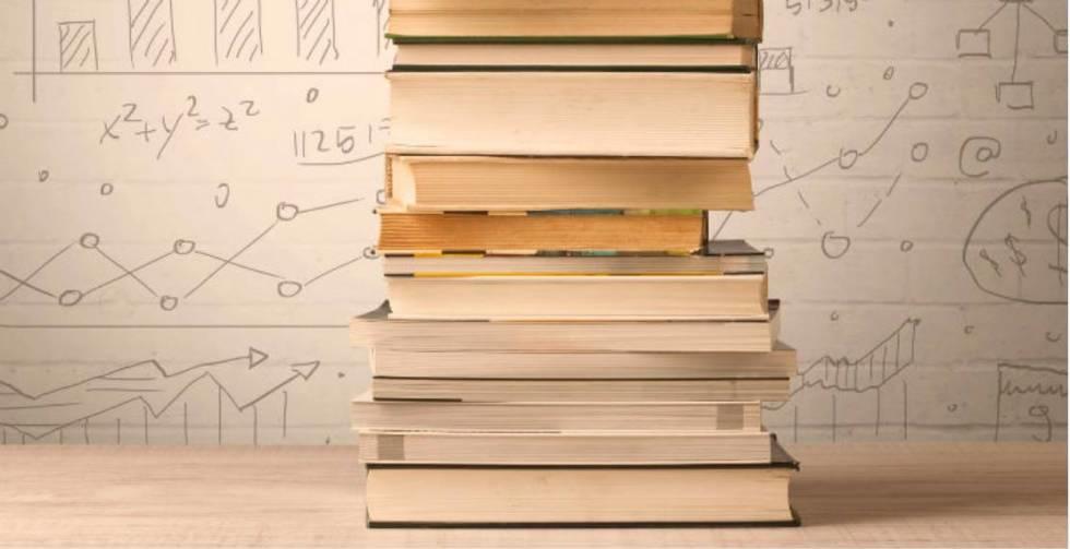 Libros apilados junto a ecuaciones matemáticas escritas.