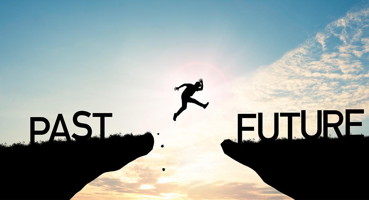 Silueta de un hombre saltando entre dos montañas que llevan por nombre "pasado y futuro"