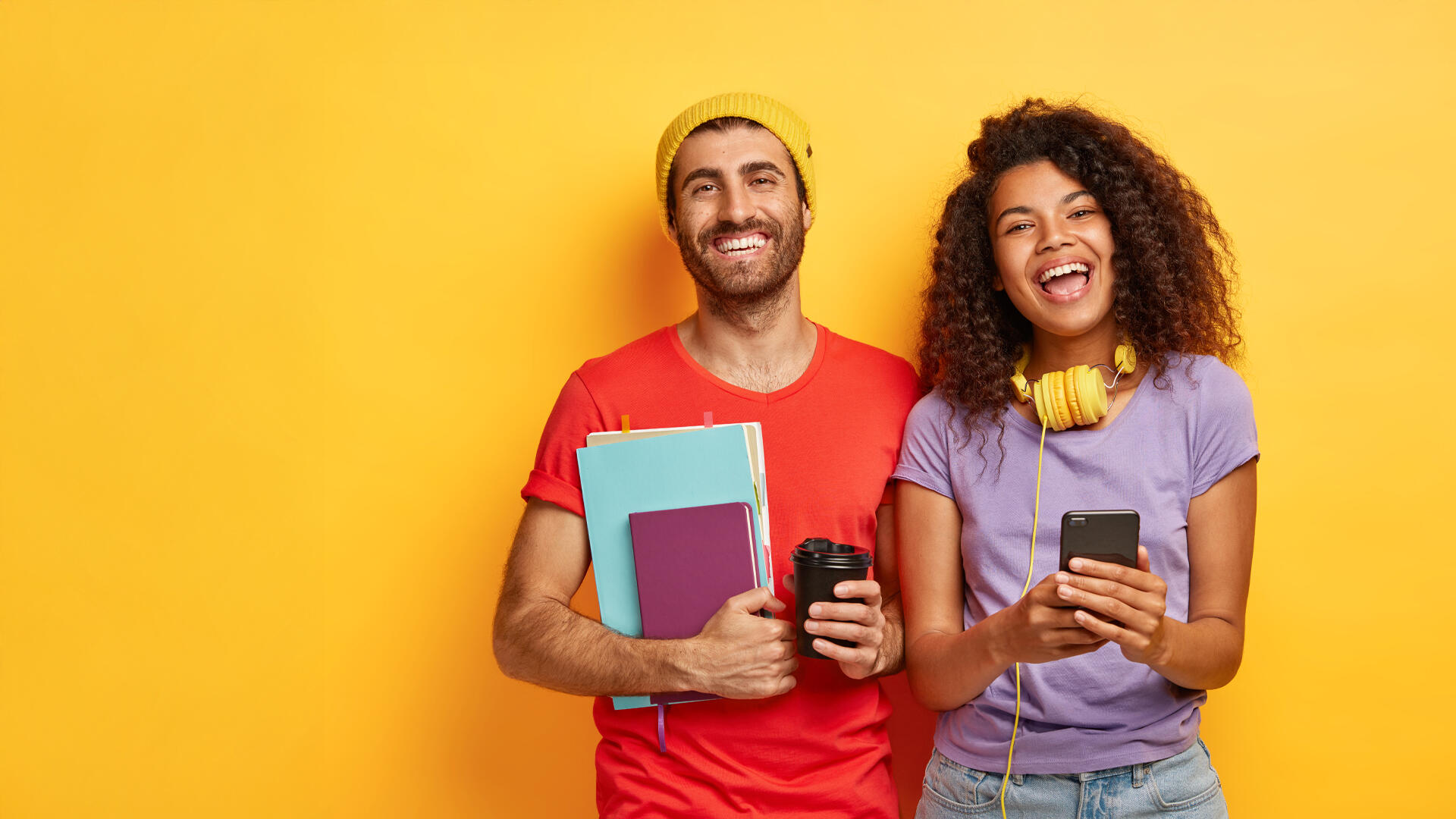 Dos jóvenes sonrientes, relajados, con materiales de estudio y fondo colorido.