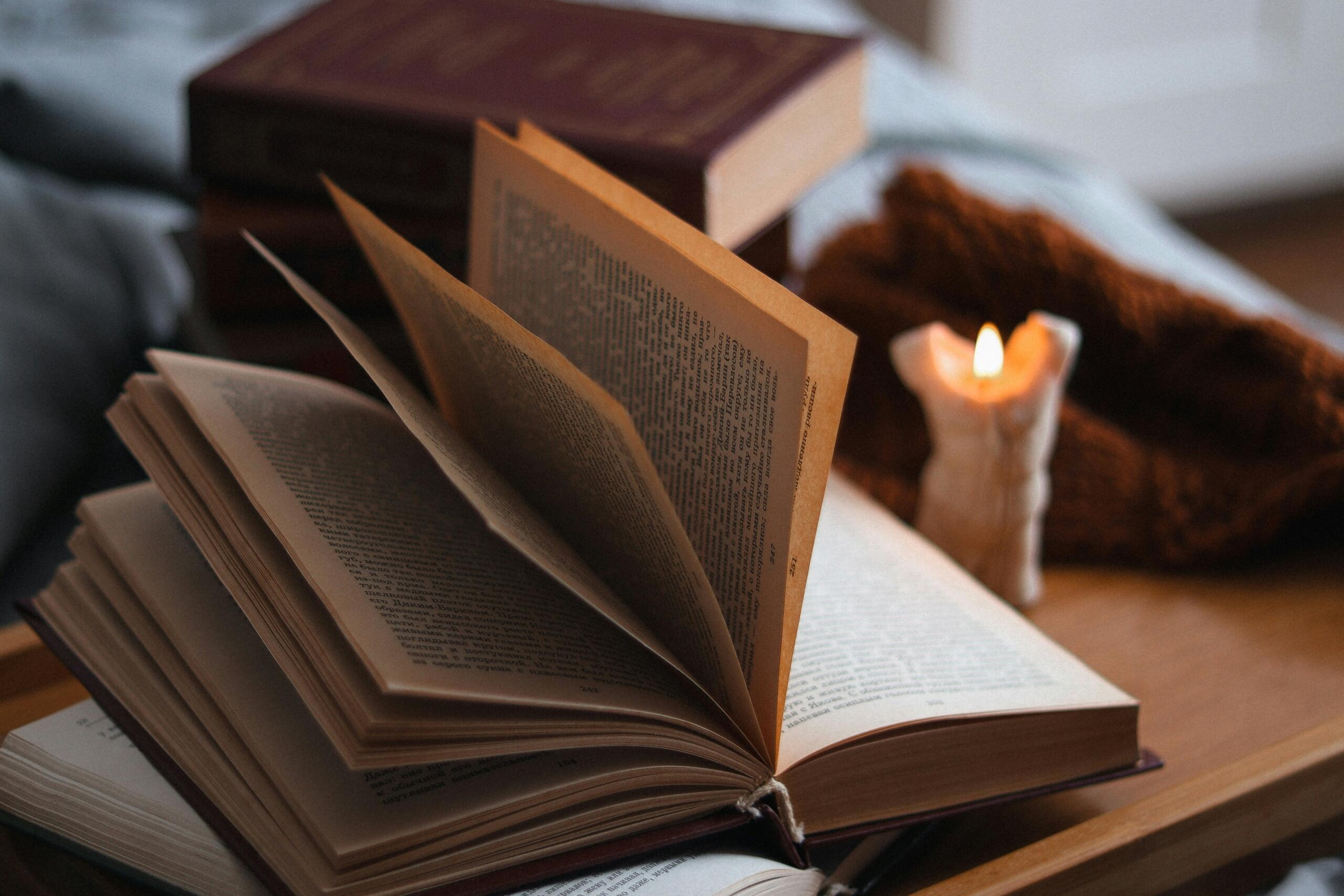 Un libro de novela abierta con el fondo de una vela prendida
