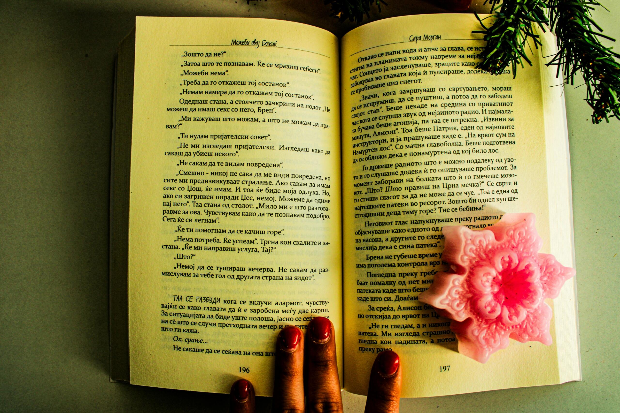 Un libro abierto escrito en ruso con una vela al lado