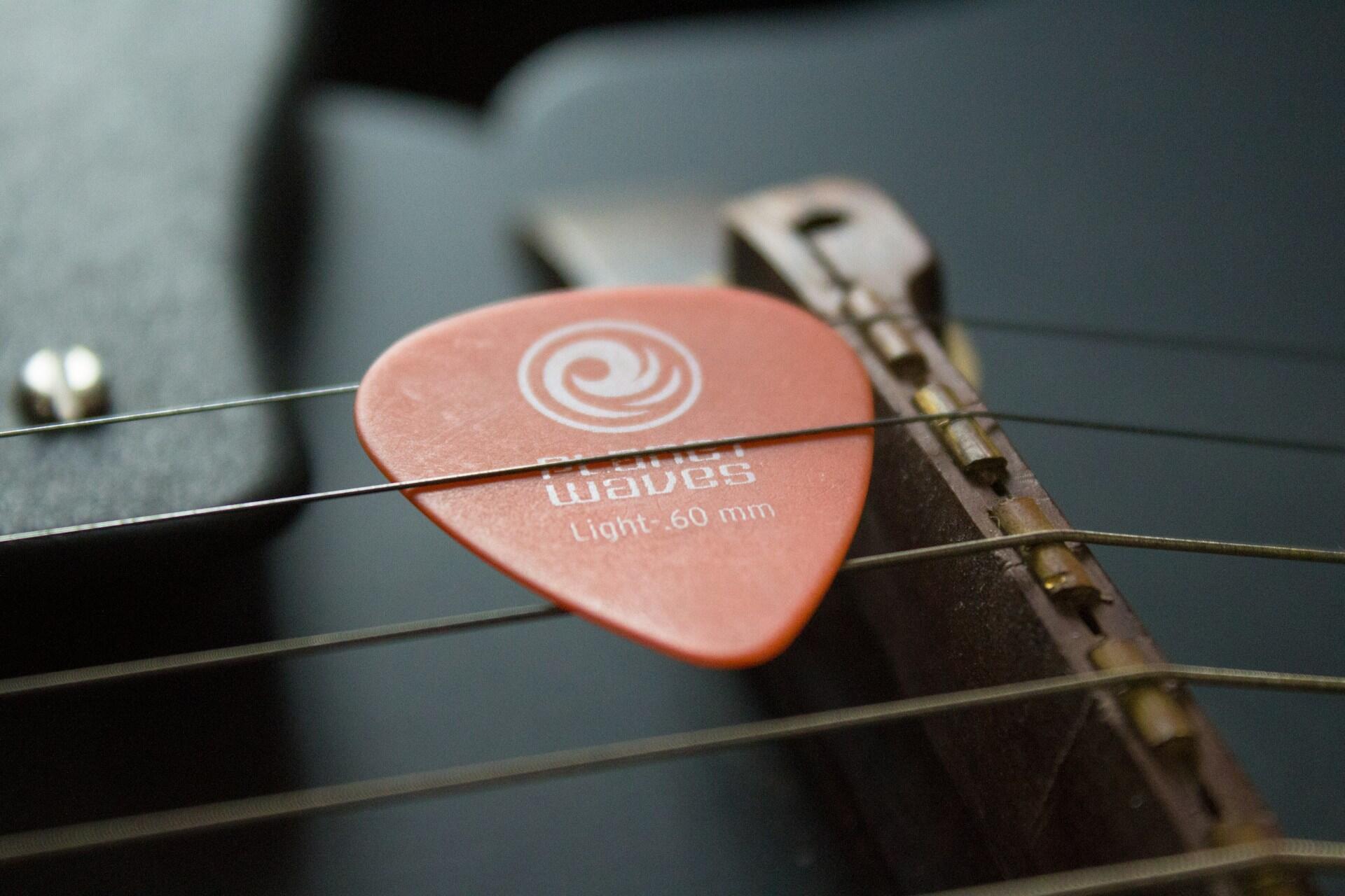 Plektrum auf den Saiten einer Gitarre