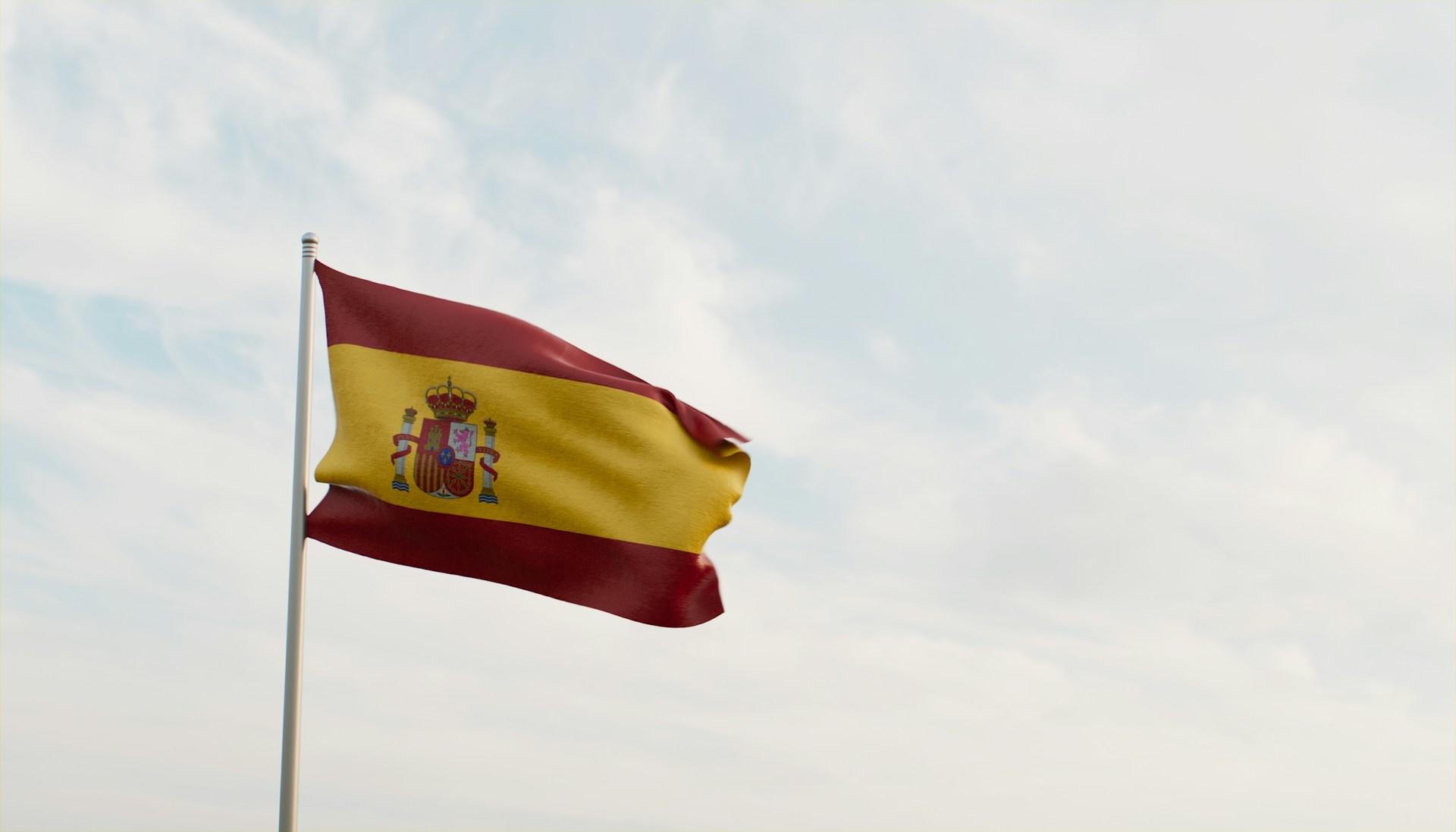 Die spanische Flagge vor grauem Himmel