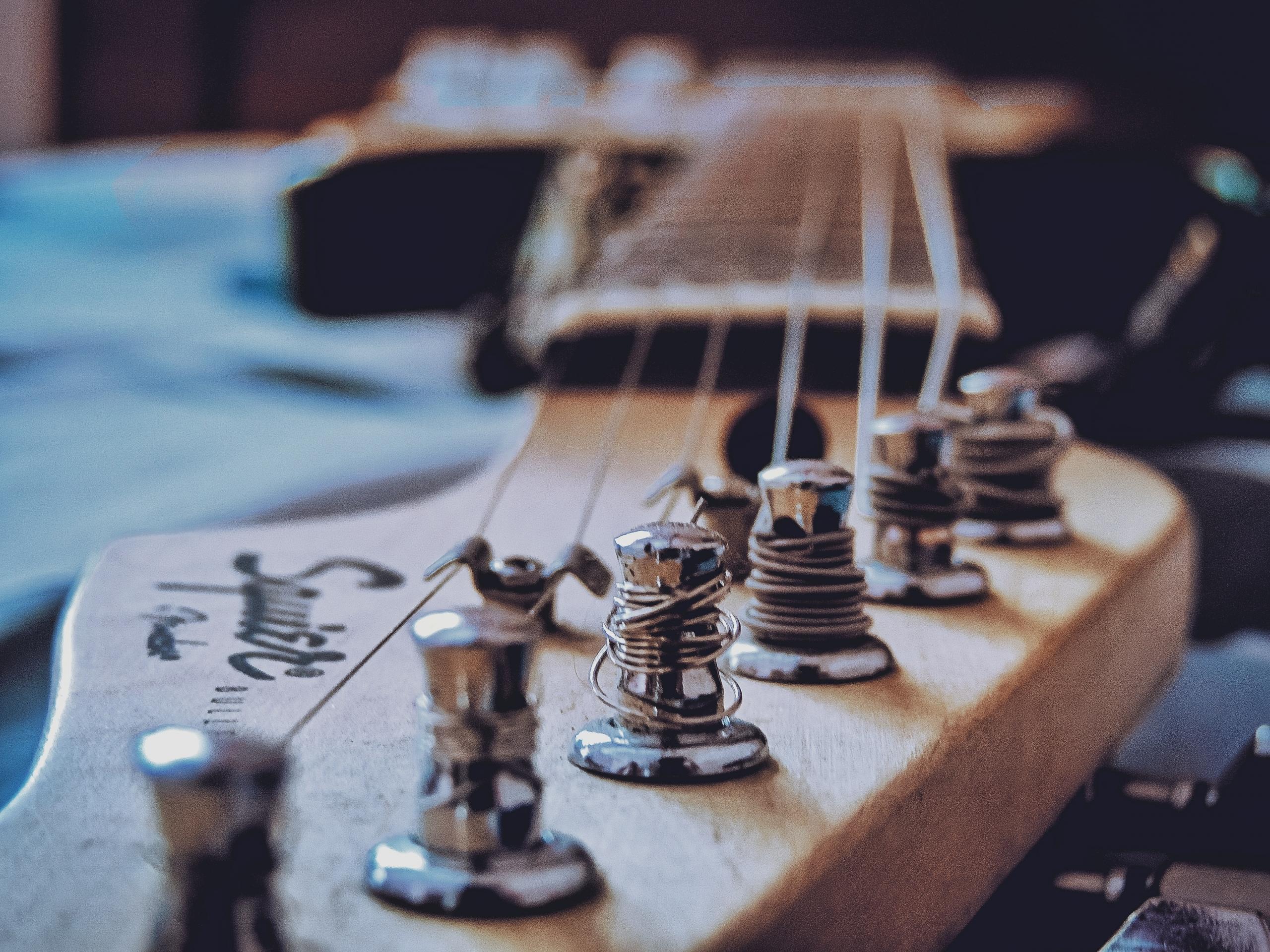 Die Gitarrensaiten werden zwischen der Kopfmechanik und dem Steg der Gitarre eingespannt.
