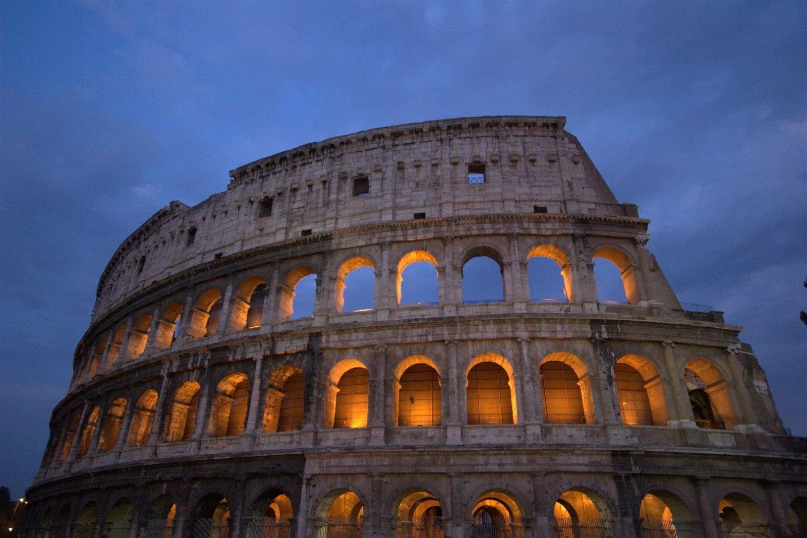 Beleuchtetes Colosseum im Abendhimmel.