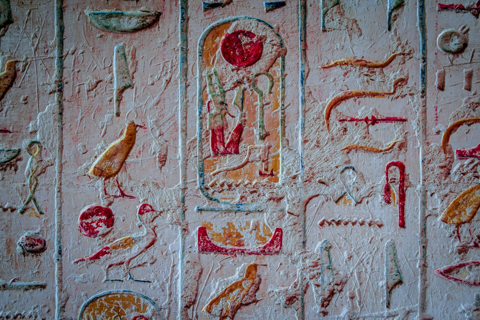 Rote und gelbe Schriftzeichen auf weißer Wand.