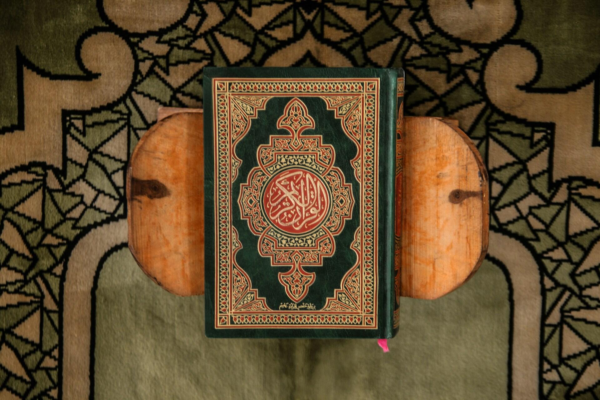 Verzierter Koran auf Holzhocker auf Teppich.