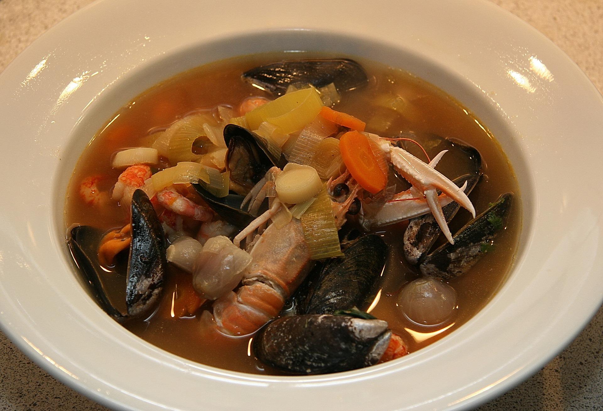 Ein weißer Suppenteller mit Fischsuppe weckt Sehnsucht nach den Küsten Frankreichs.