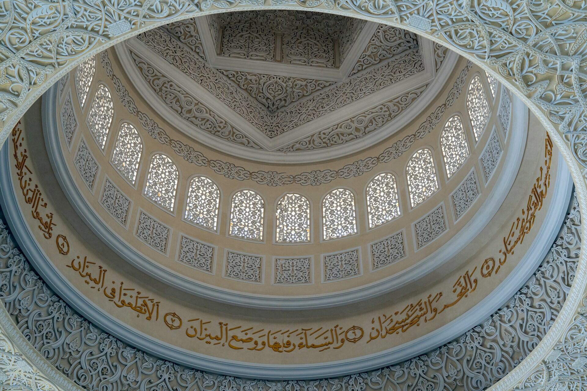 Verziertes Dach einer Kuppel mit arabischer Schrift.