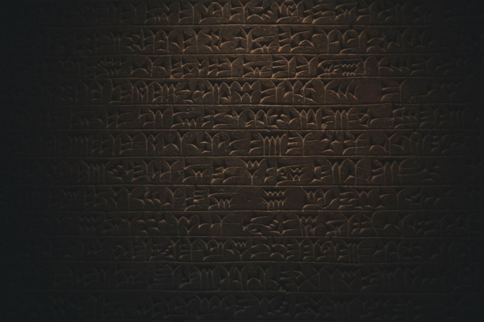 Wand mit eingeritzten Schriftzeichen.