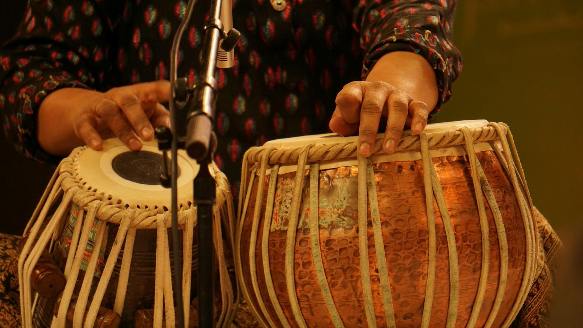 Person die eine Tabla Trommel spielt