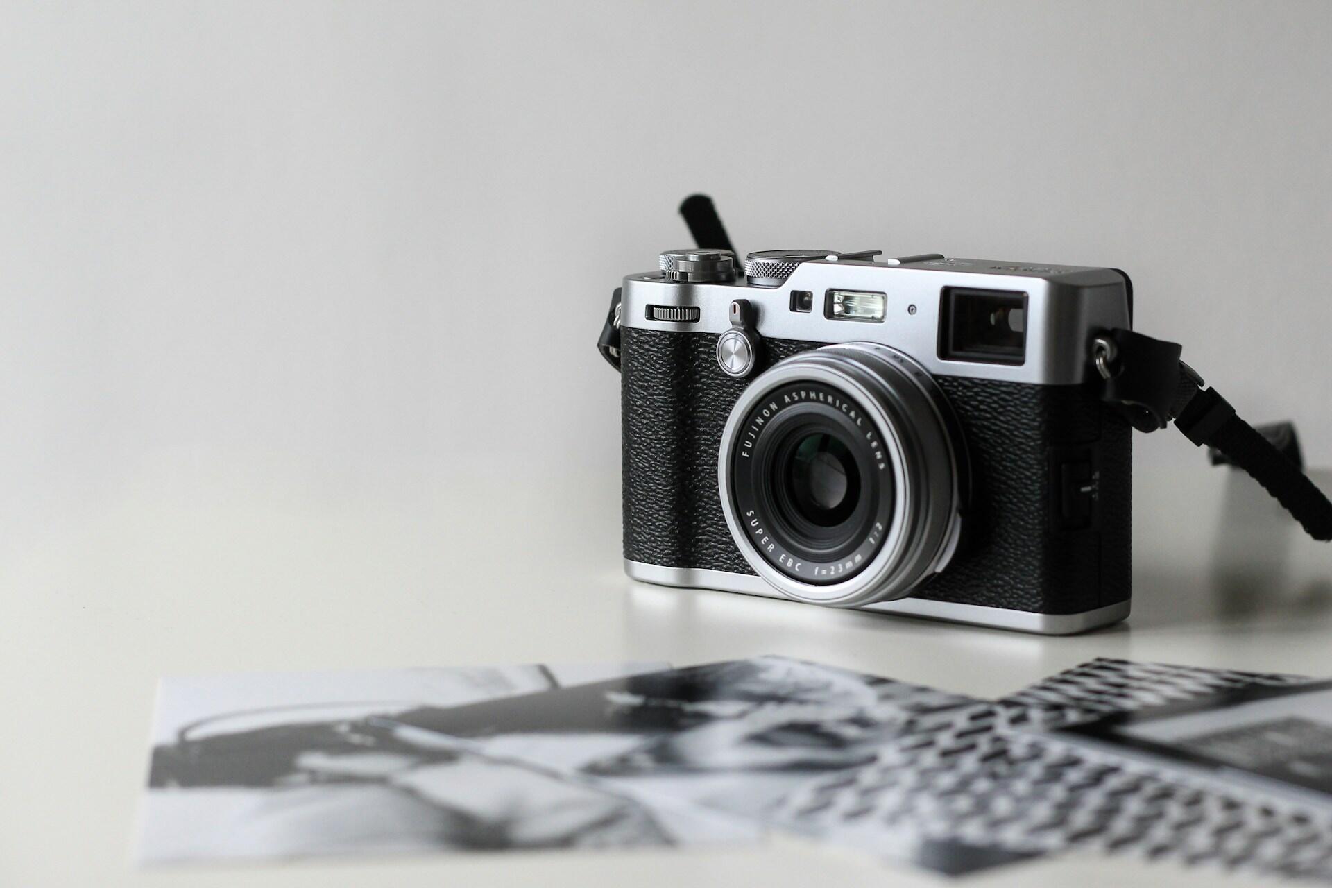 Analoge Kamera auf Tisch neben Fotos.