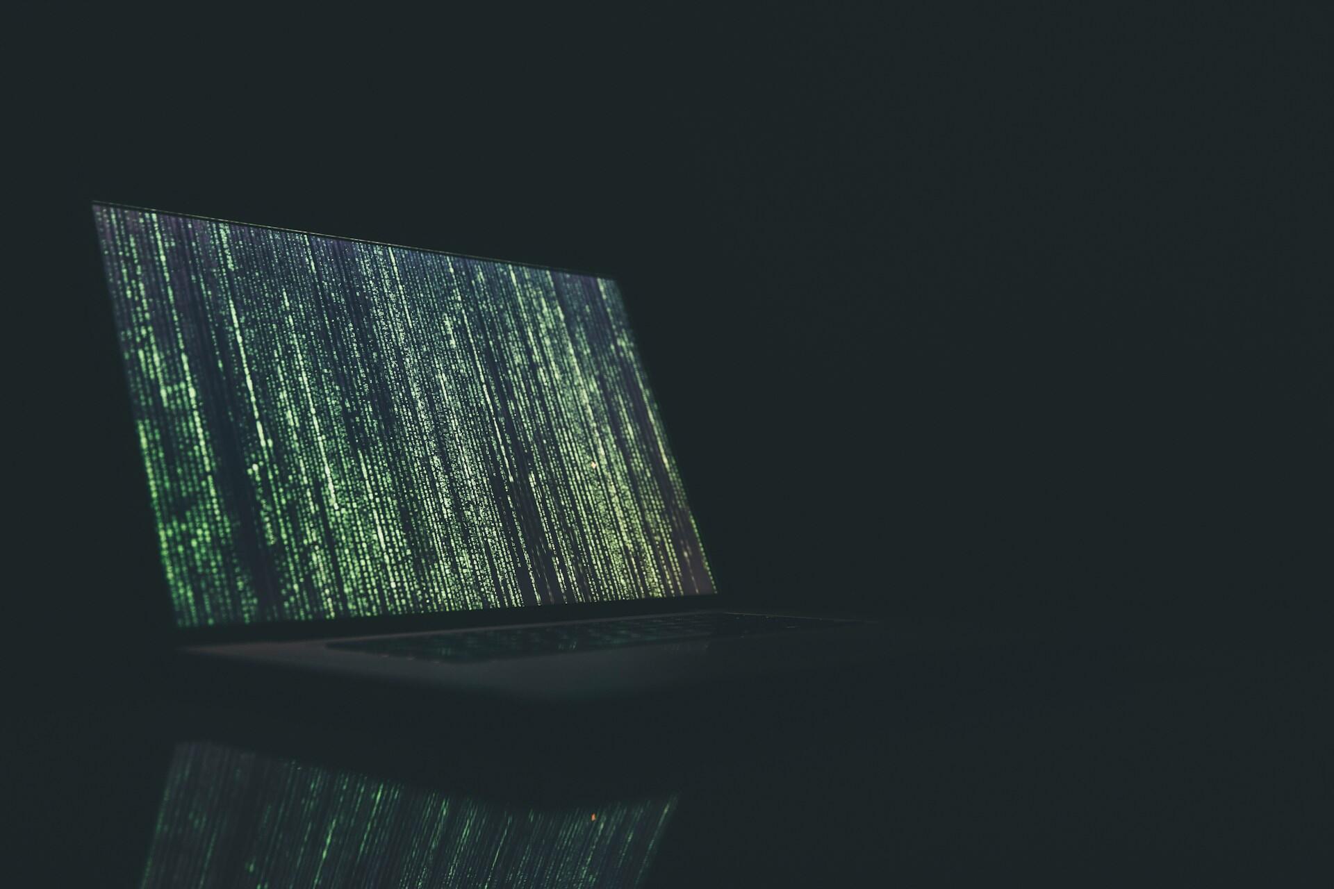 Ein Computer auf dem ein Code ausgeführt wird uns grüne Zahlenreihen zu erkennen sind.