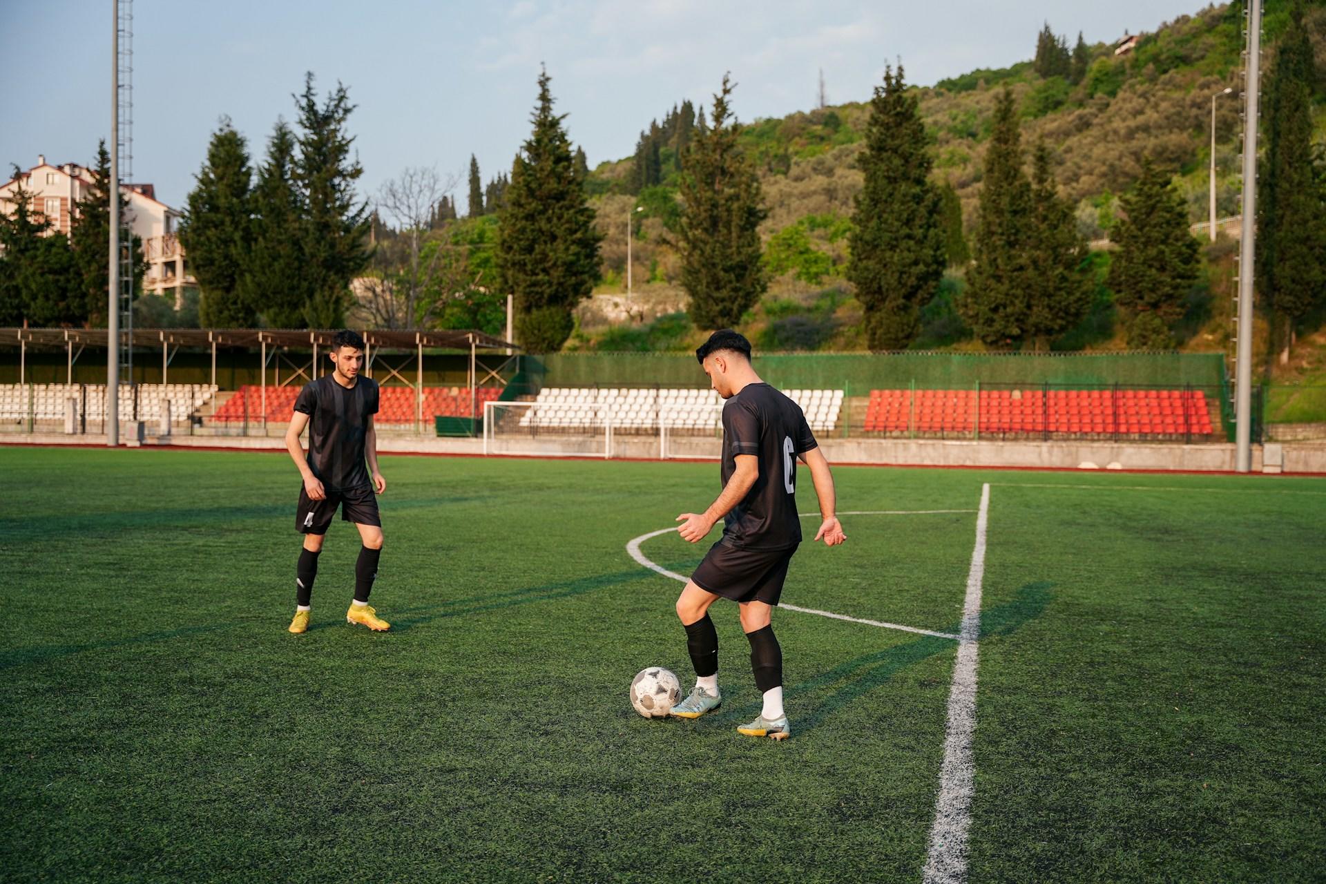 Zwei Fußballspieler auf einem Spielfeld tragen Shorts