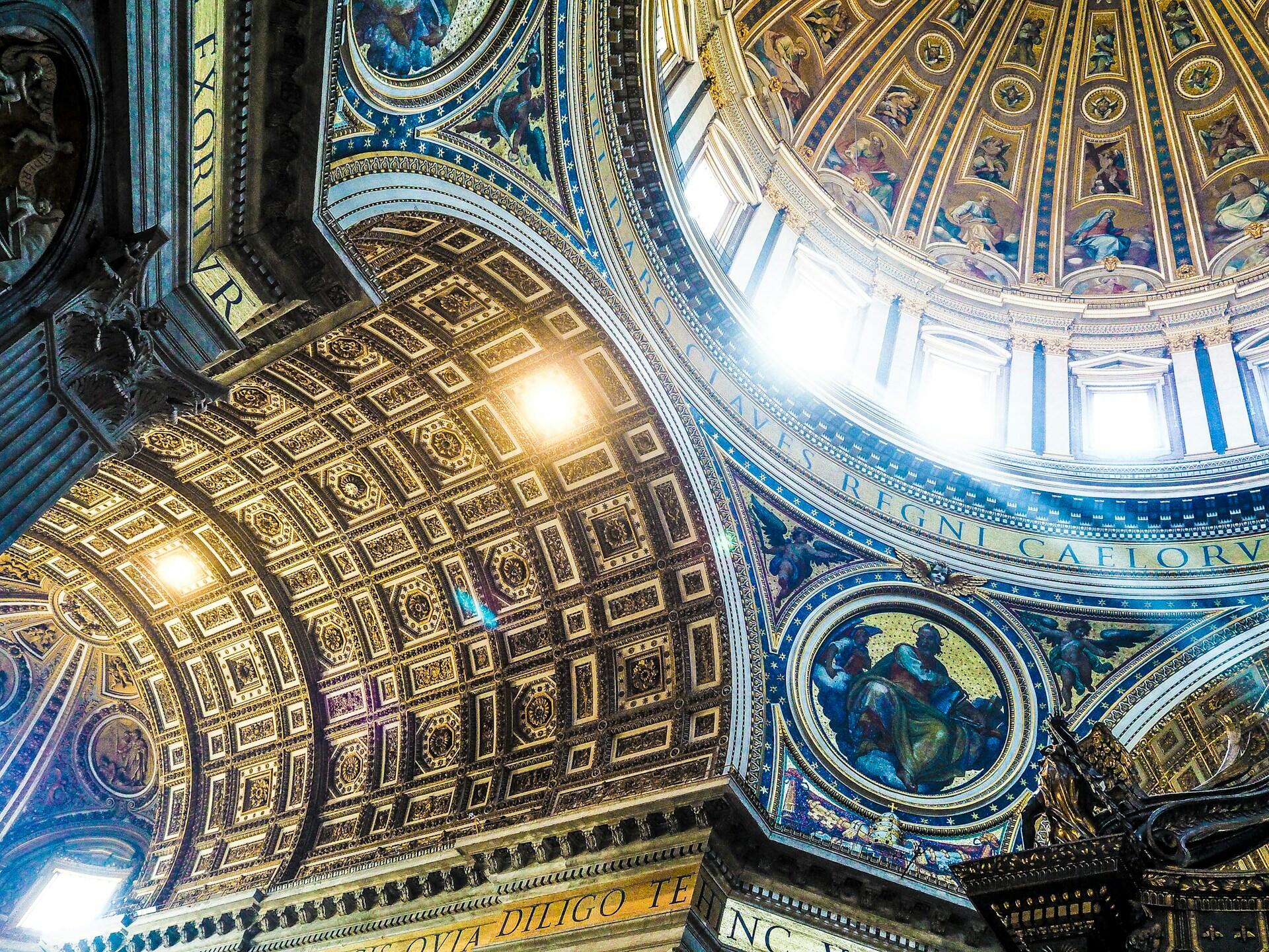Dekorierte Decke einer Kirche mit Fenstern.