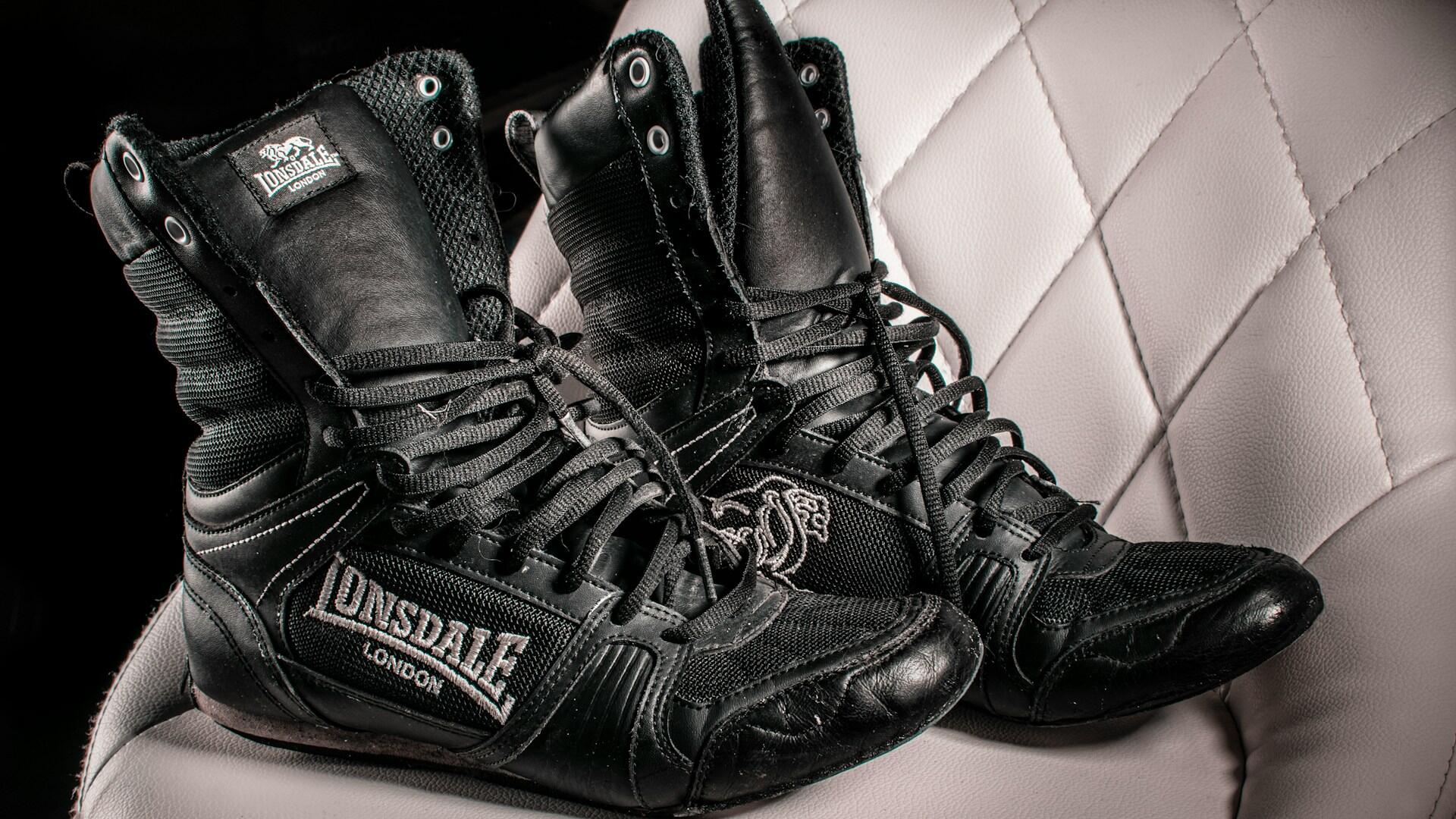 Schwarze Boxschuhe auf weißem Stuhl