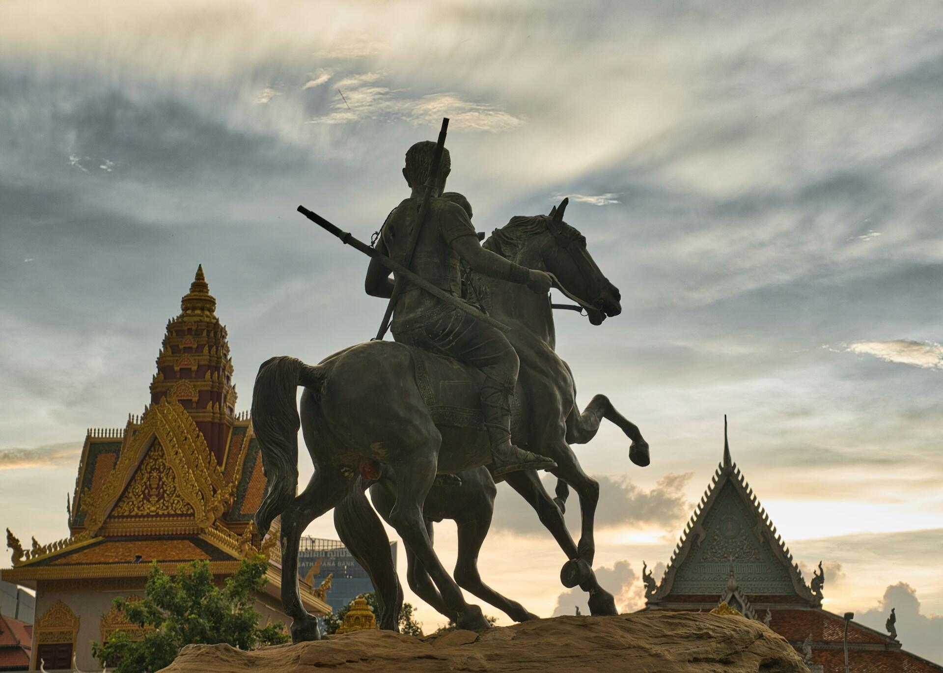 Statue von Mann auf Pferd vor Gebäuden.