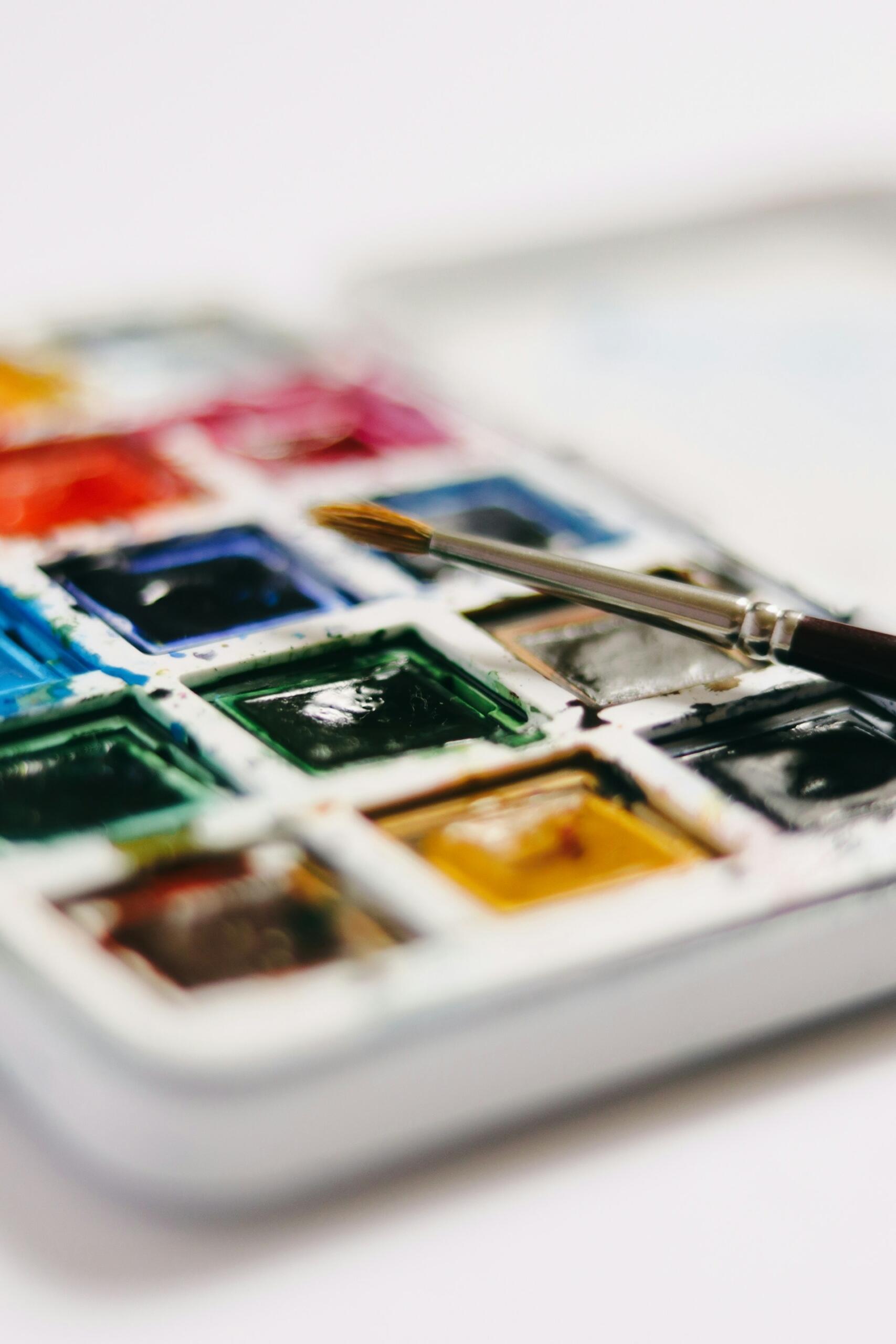 Eine Aquarellpalette und ein Pinsel.
