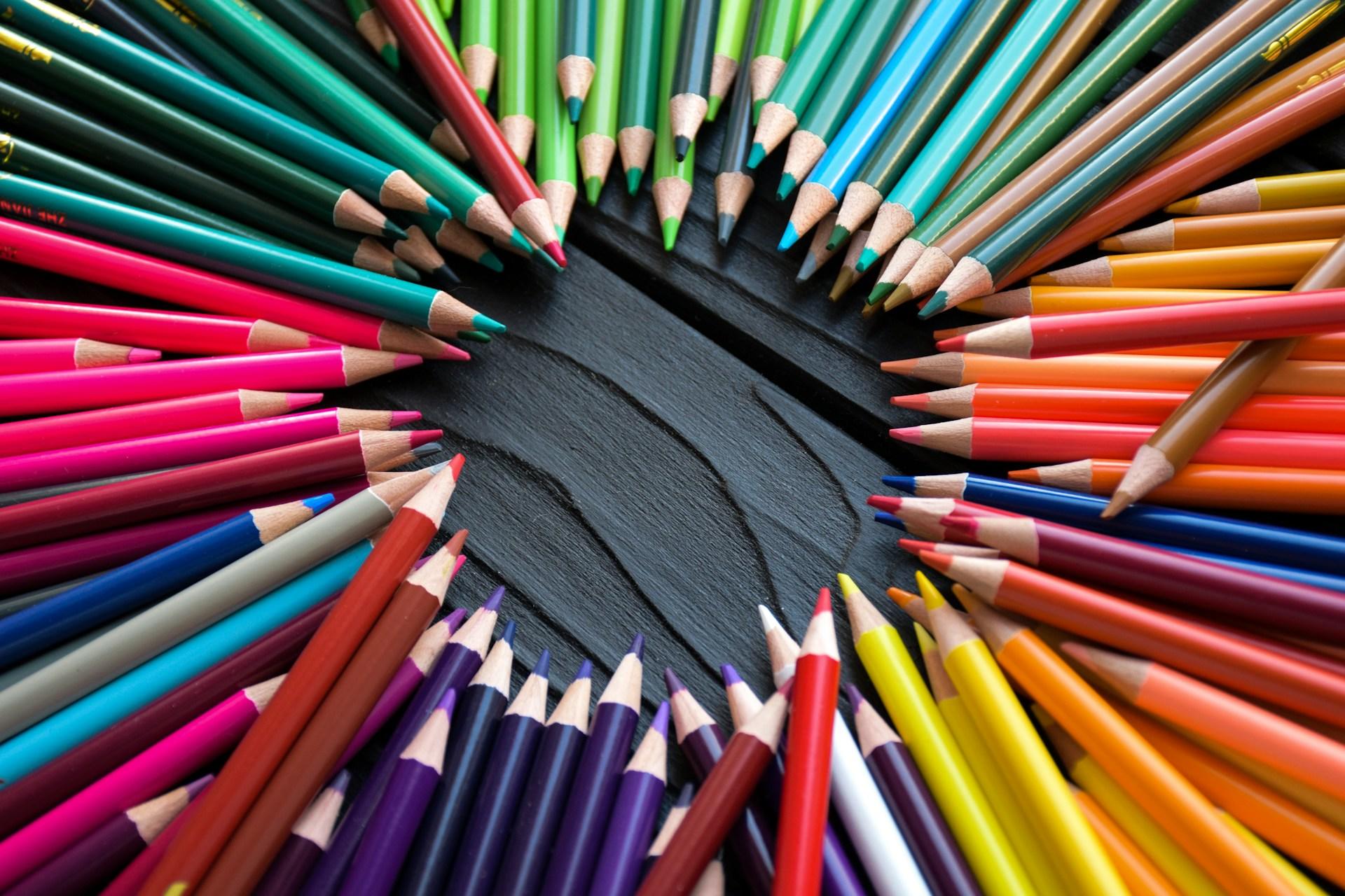 Viele Buntstifte liegen mit der Spitze zueinander