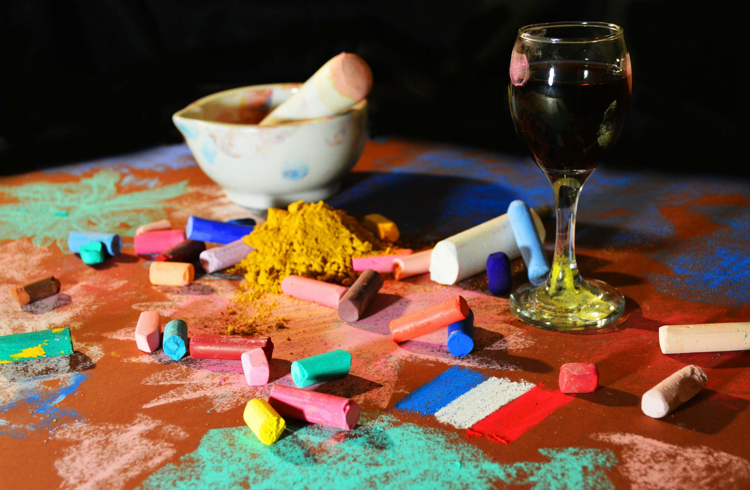 Einige Kreiden, Staub, ein Mörser und ein Glas Wein.