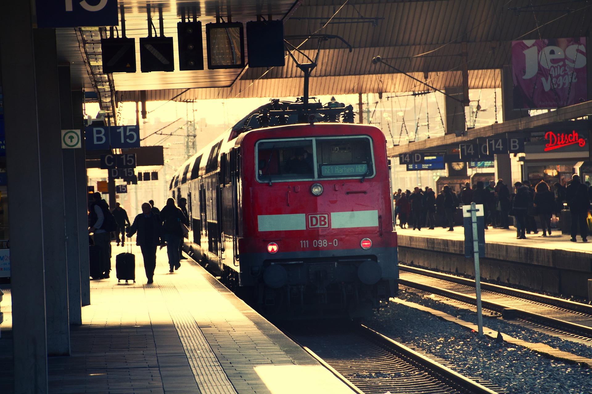 Bahnhof mit Menschen und rotem Zug 