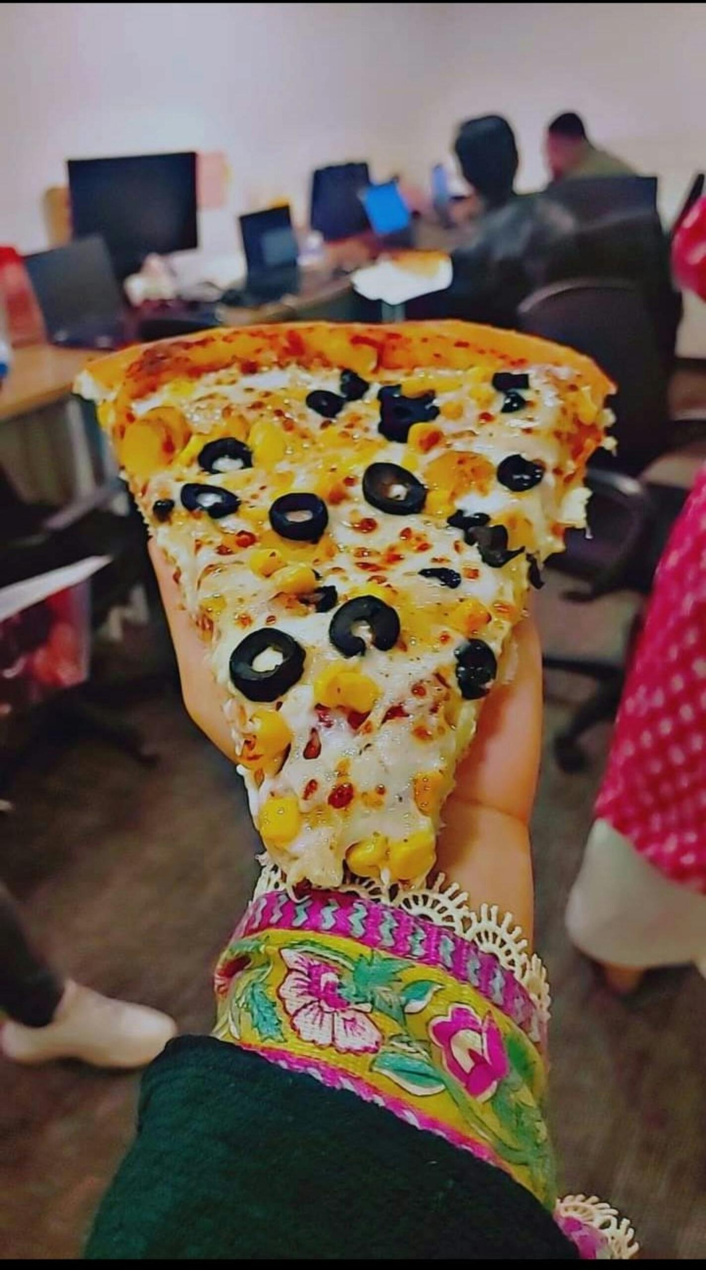 Ein dickes Stück Pizza mit Oliven.