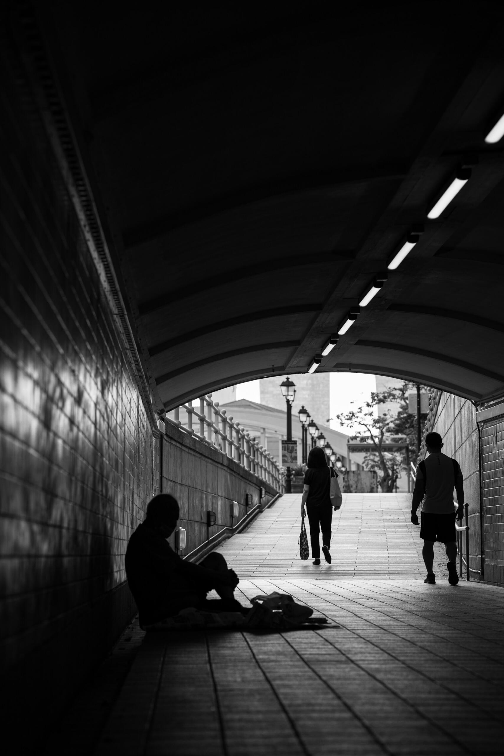 Ein Obdachloser sitzt in einem Tunnel.