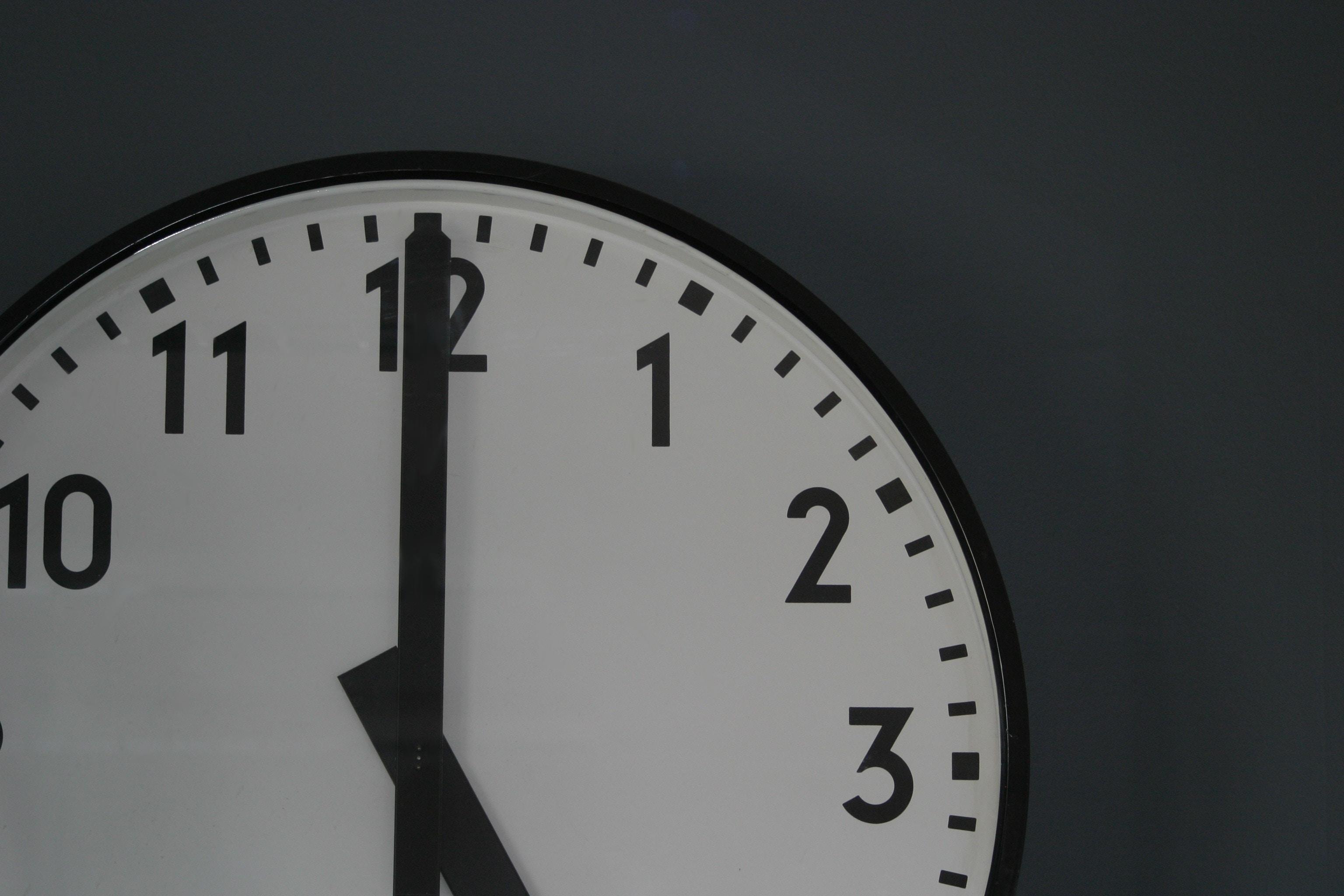 Der Zeiger einer Uhr steht auf der zwölf