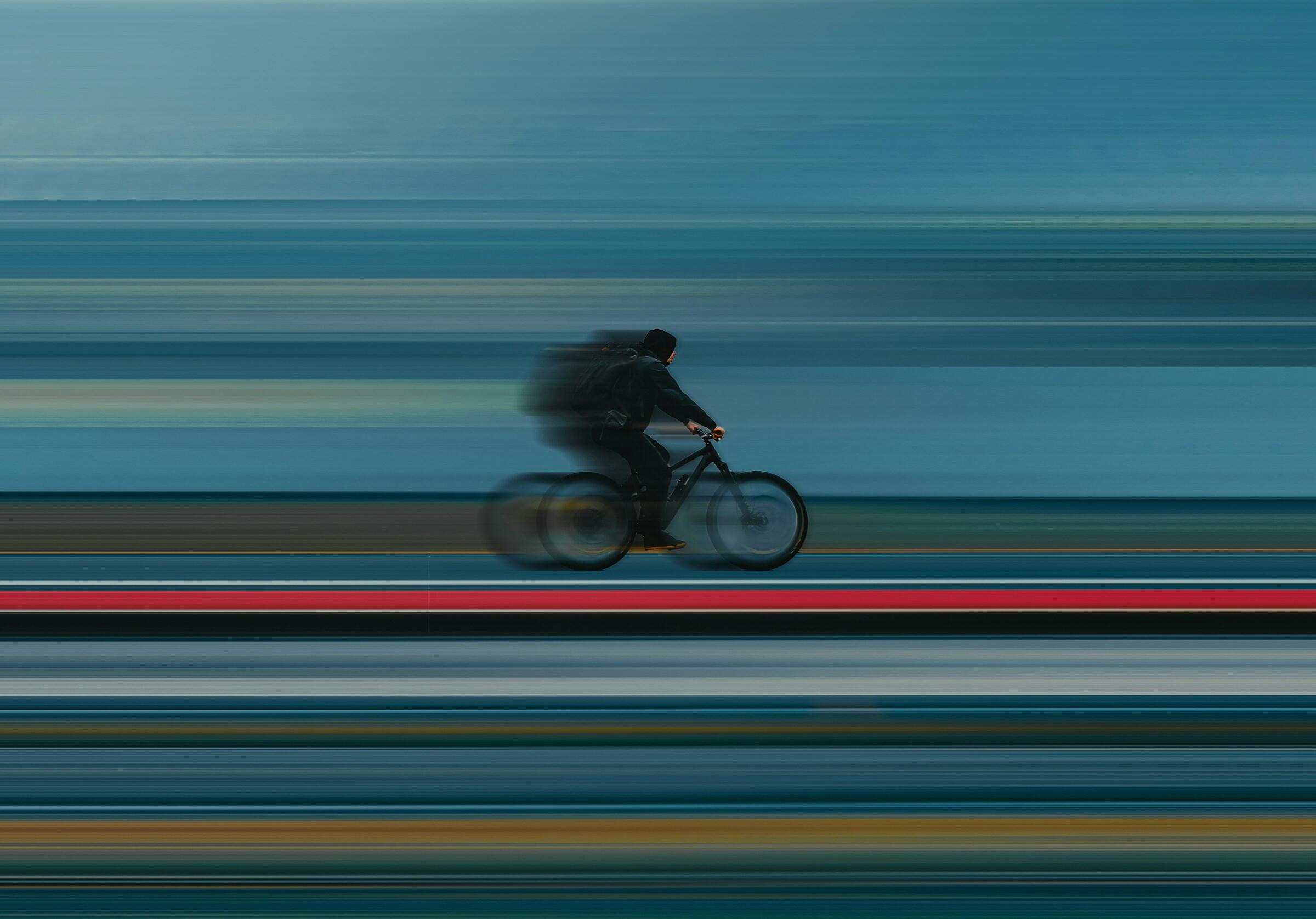 Ein Mann auf einem Fahrrad mit viel Bewegungsunschärfe.