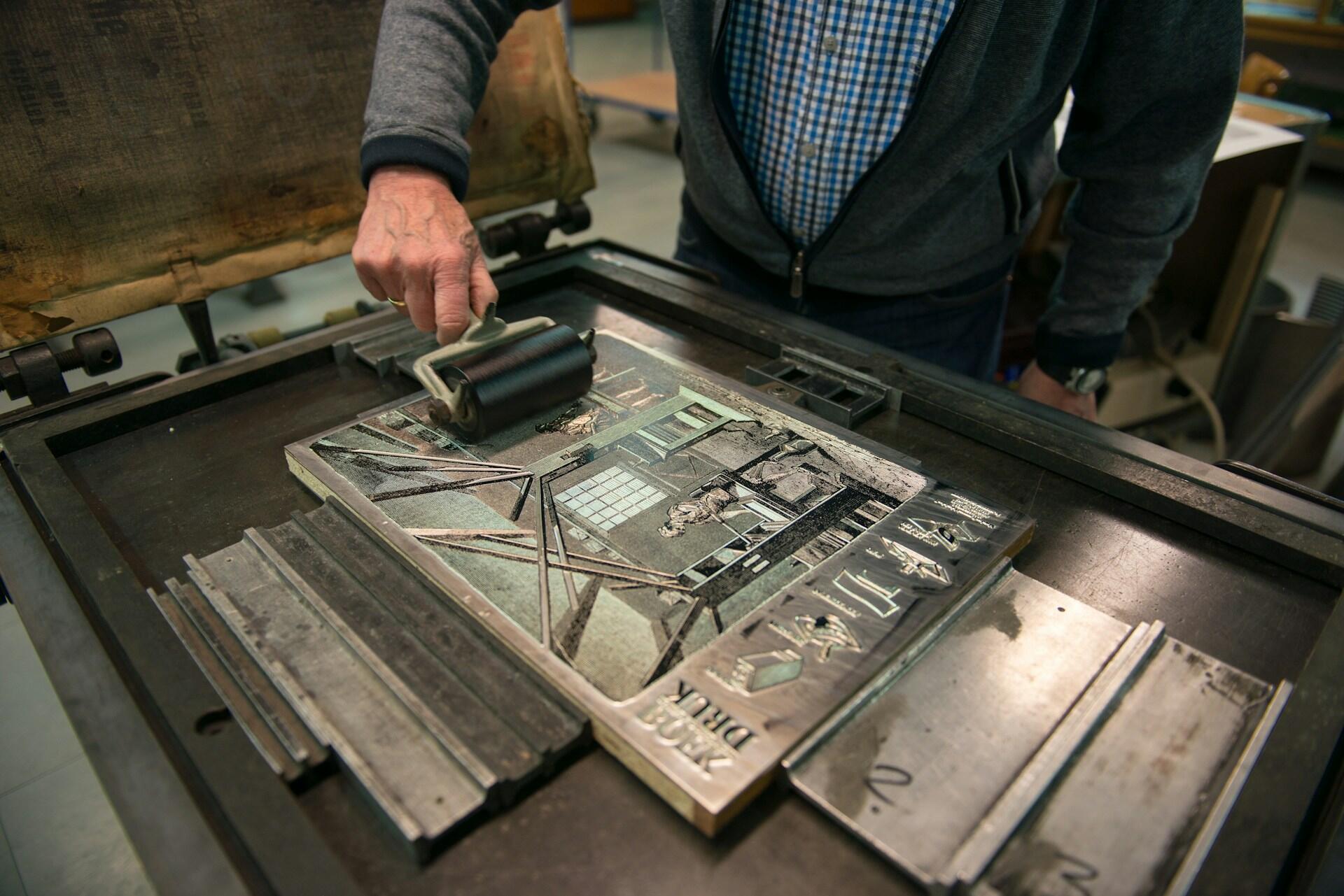 Mann druckt kleine Walze über Vorlage.