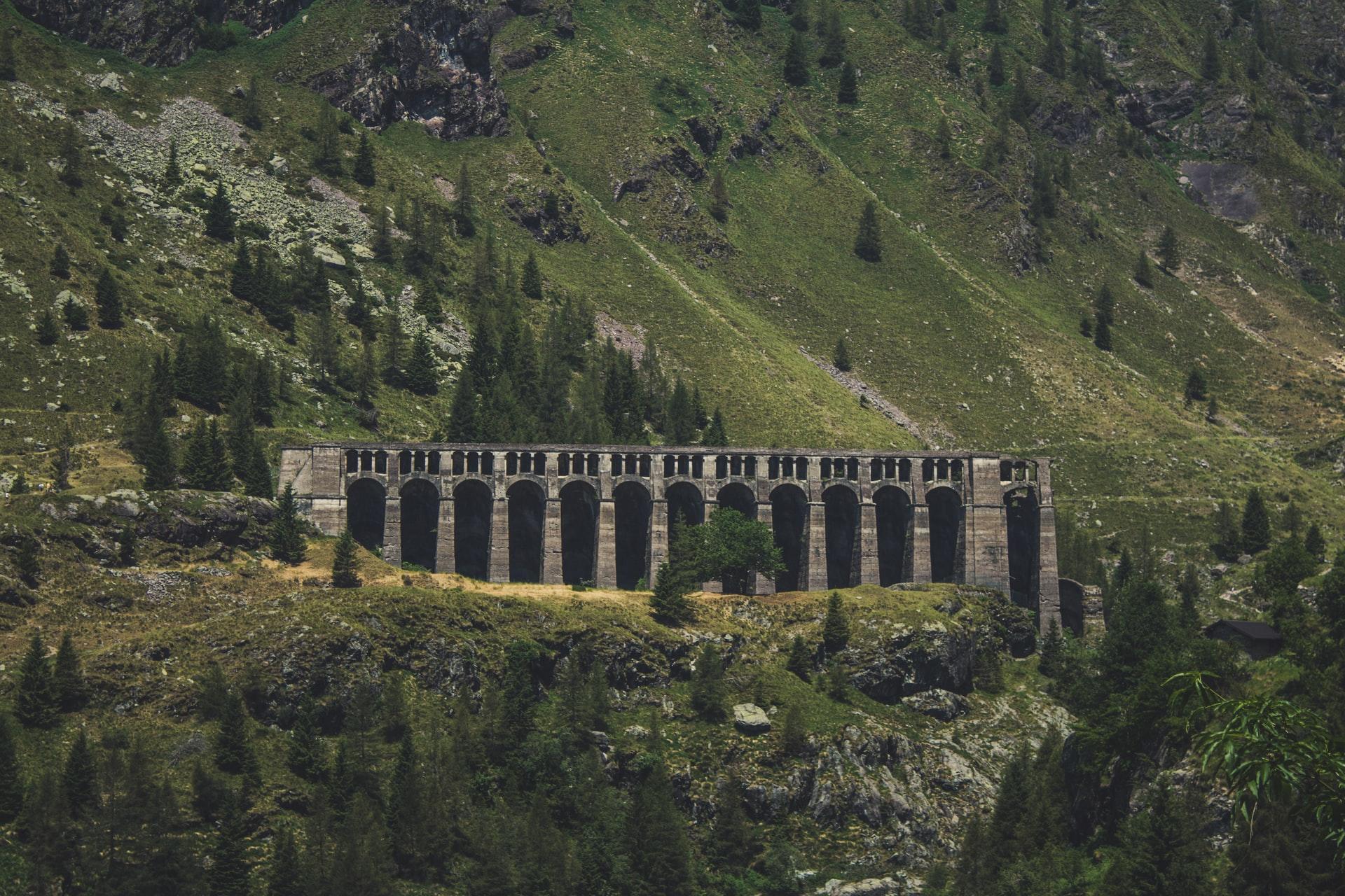 Talsperre in grün bewachsenem Bergtal.